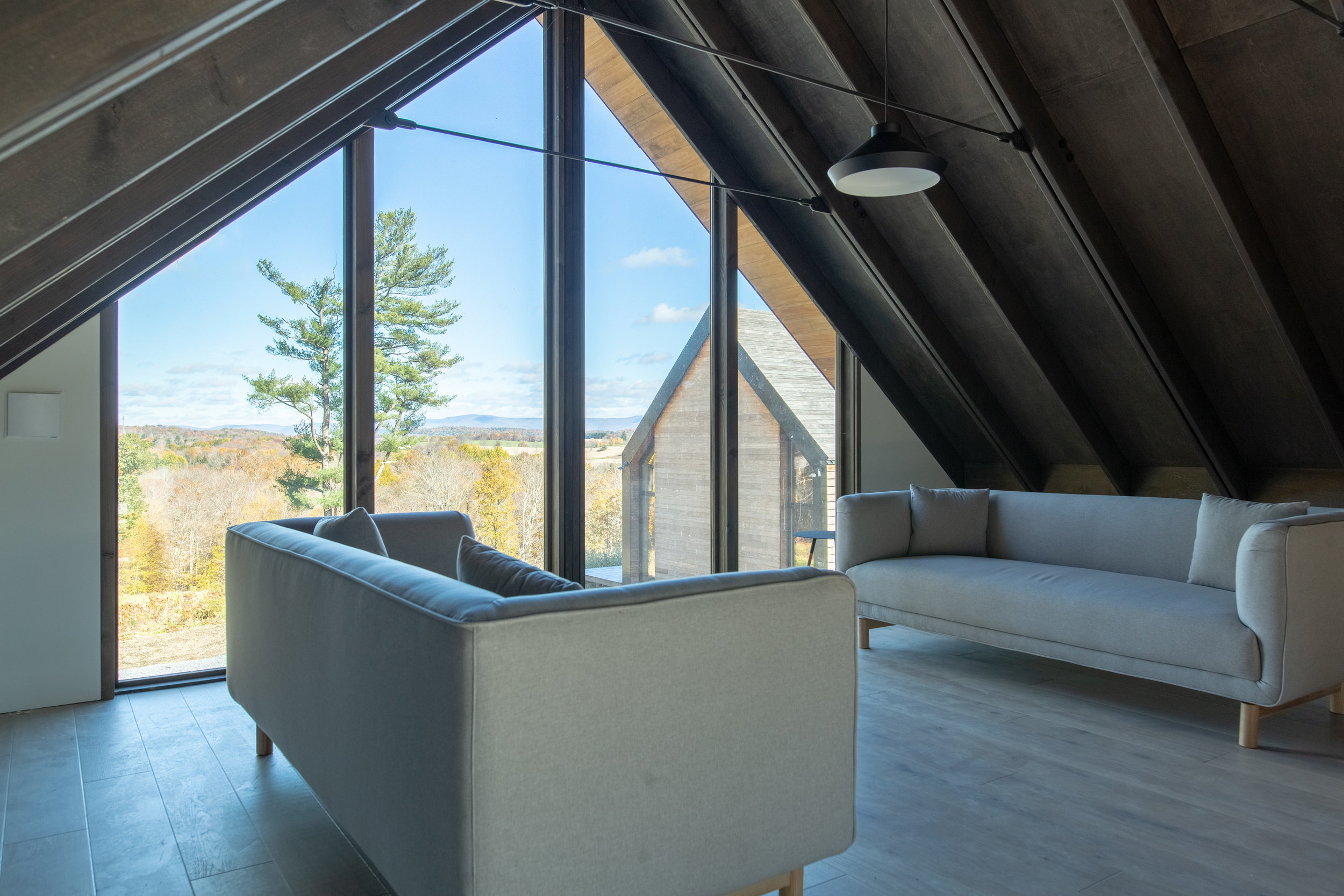 Carefully placed windows overlook nearby oak trees, the river below, then the rolling hills, and distant mountain ranges beyond