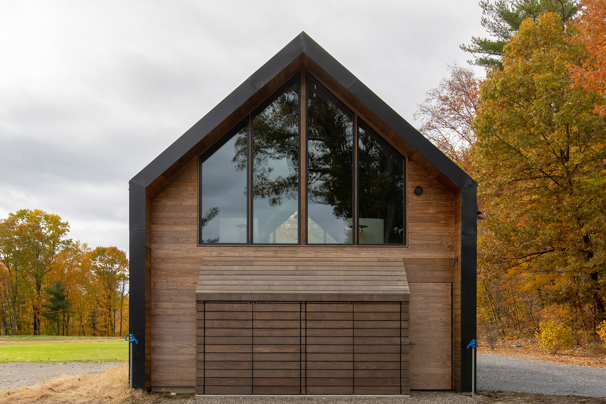 Lockable firewood and waste bin storage echo the shape of the loft windows above