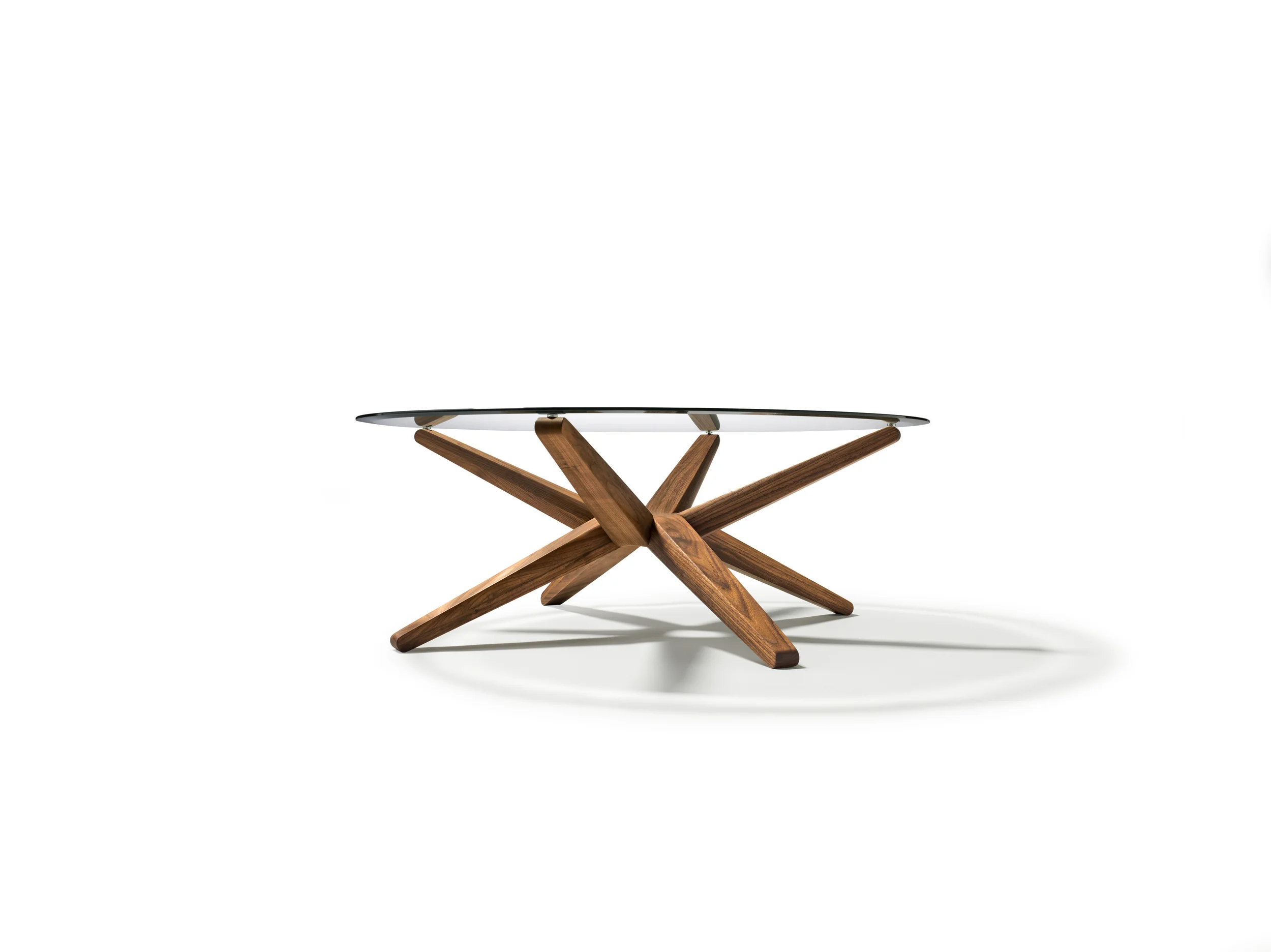 STERN coffee table The centrepiece of the stern coffee table is a circular node from which eight identical rays branch out. Cleverly directed alternately upwards and downwards, the rays simultaneously form the legs and supports for a round glass top. The downward bevelled edge of the clear glass top creates a charming play of colour and light. Text/Photos/Producer: TEAM 7 Design: Jacob Strobel 2011