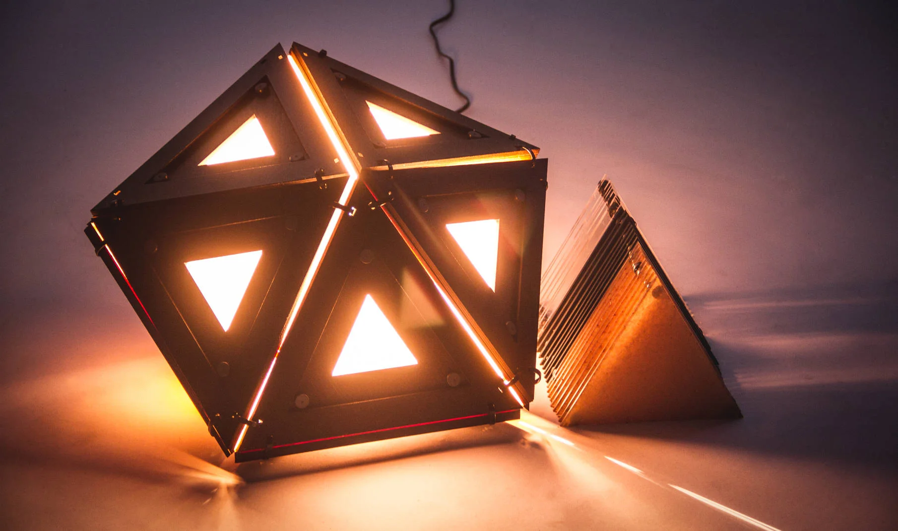 The Mod Box is a modular light box that features different panels onto which different light modifiers may be attached to. With different panel options, users can control and manipulate the amount of light that comes out. If the user wishes to prevent light from coming out of the back of the light, they can simply attach opaque panels on the back and transparent panels on the front. As it stands now, there are three different modifier panels available: a completely transparent panel to allow maximum light flow, a semi-opaque panel to slightly dim the light flow, and a completely opaque panel to prevent light from coming out whichever panel it is affixed to. Medium: Birch Plywood, Wood Stain, Acrylic Sheets, Magnets, Zip-Ties, and a 60W Lightbulb All panels were precision cut with a laser cutter and then sanded to perfection before staining. Final Project for DESMA 22: FORM