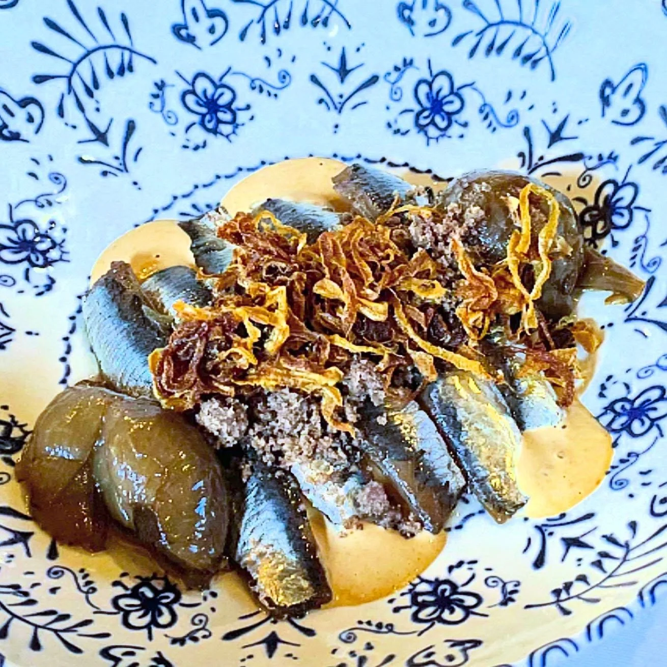 Umami Layered Delight.  Mouth watering, savory, complex yet super balanced.  Anchovy salad with fresh seasonal chanterelle mushrooms, poached onion, and a bed of magic dressing. #NorthernSpain #foodie #spainfoodie #Spainfood #foodtour #privatetour #c