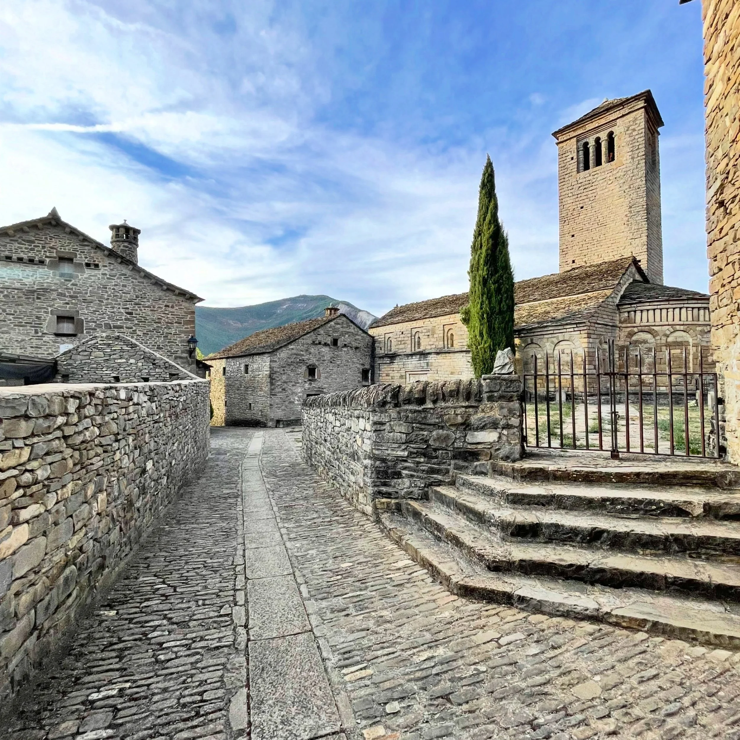 Strolling the 10th c.  Pre-Romanesque (Mozarabic) church with characteristic features, cobblestone street and traditional mountain architecture, including a typical chimney.  #NorthernSpain #ruralarchitecture #preromanesque #customtours #offthebeaten