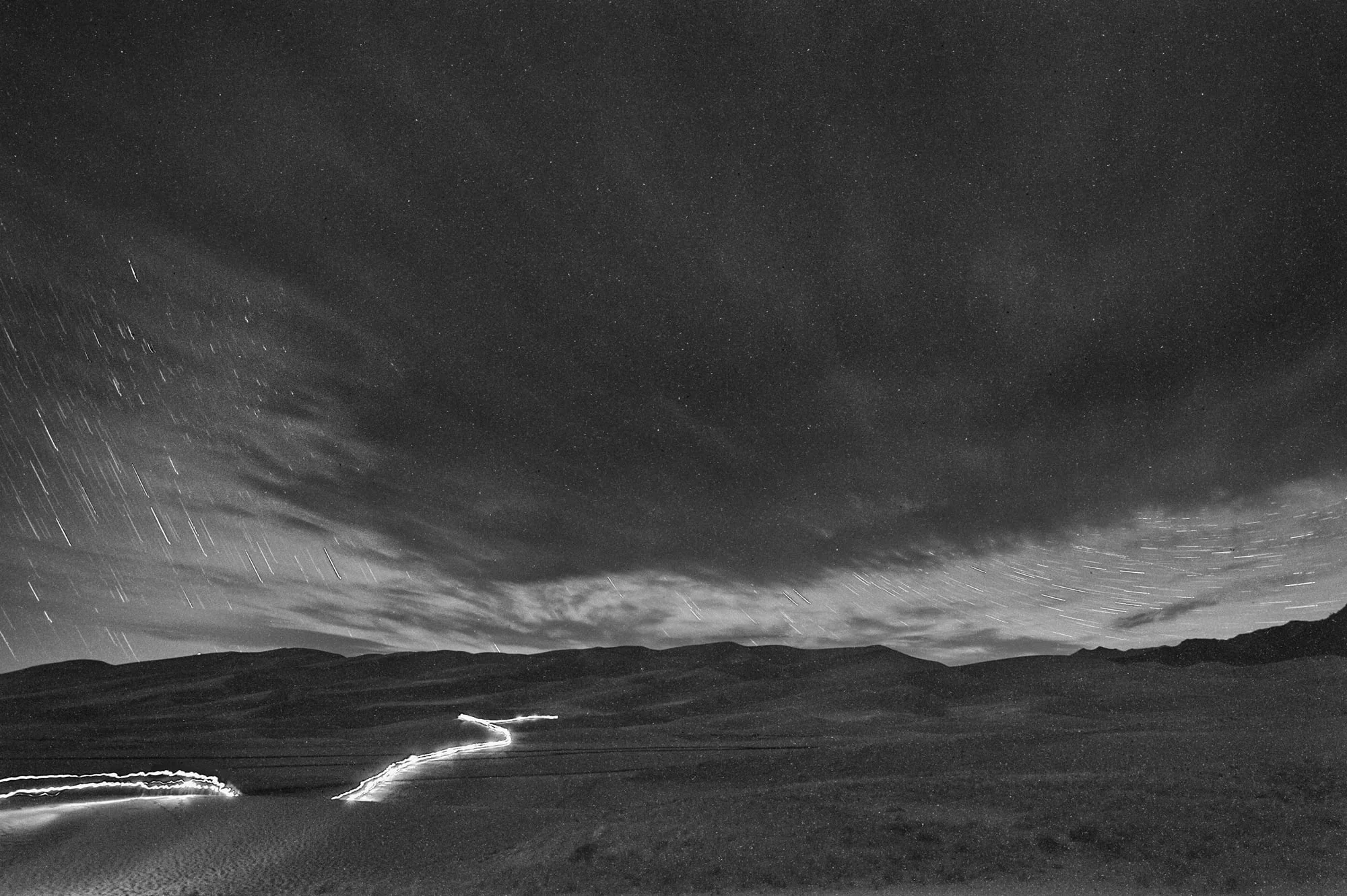 This is my favorite shot from the night. Six 3-minute exposures stacked (totaling 18 minutes) of four gals hiking down from the dunes after dark with headlamps and flashlights. But the lack of shadows on the dunes is disappointing. © Matt Hill