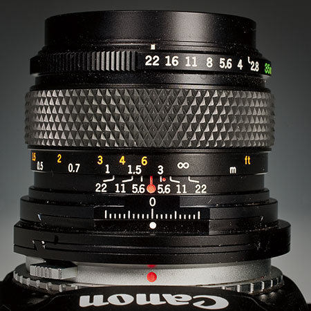This manual focus Olympus Zuiko Shift 35mm lens shows the depth of field scale, and is set to the hyperfocal distance for f/22. By placing the infinity mark just inside the right-hand 22 on the DOF scale, the HFD is set. The actual focal point is a little more than 7 feet, and the depth of field extends from about 4 feet to infinity. The HFD increases as the aperture diameter is increased, and depth of field increases as the aperture gets smaller.