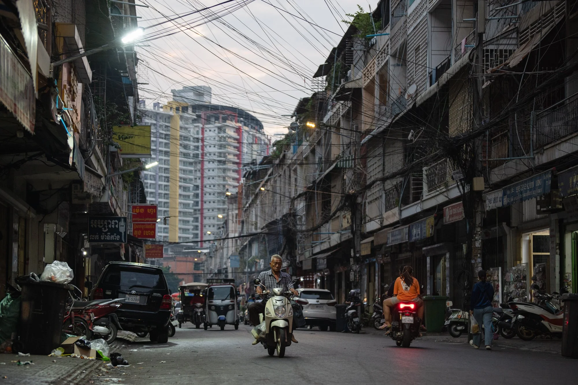 A man drives his motorbike at sunset in a historic part of town near Orussey Market in Phnom Penh, Cambodia.