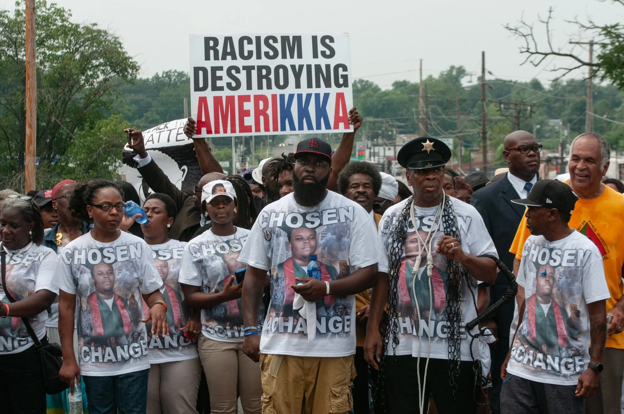 Michael Brown's father (center) with family, friends, activists and protesters walk to Greater St. Mark's Family Church in Ferguson, Missouri on August 9, 2015, for a community service to commemorate the first anniversary of Michael Brown's death.