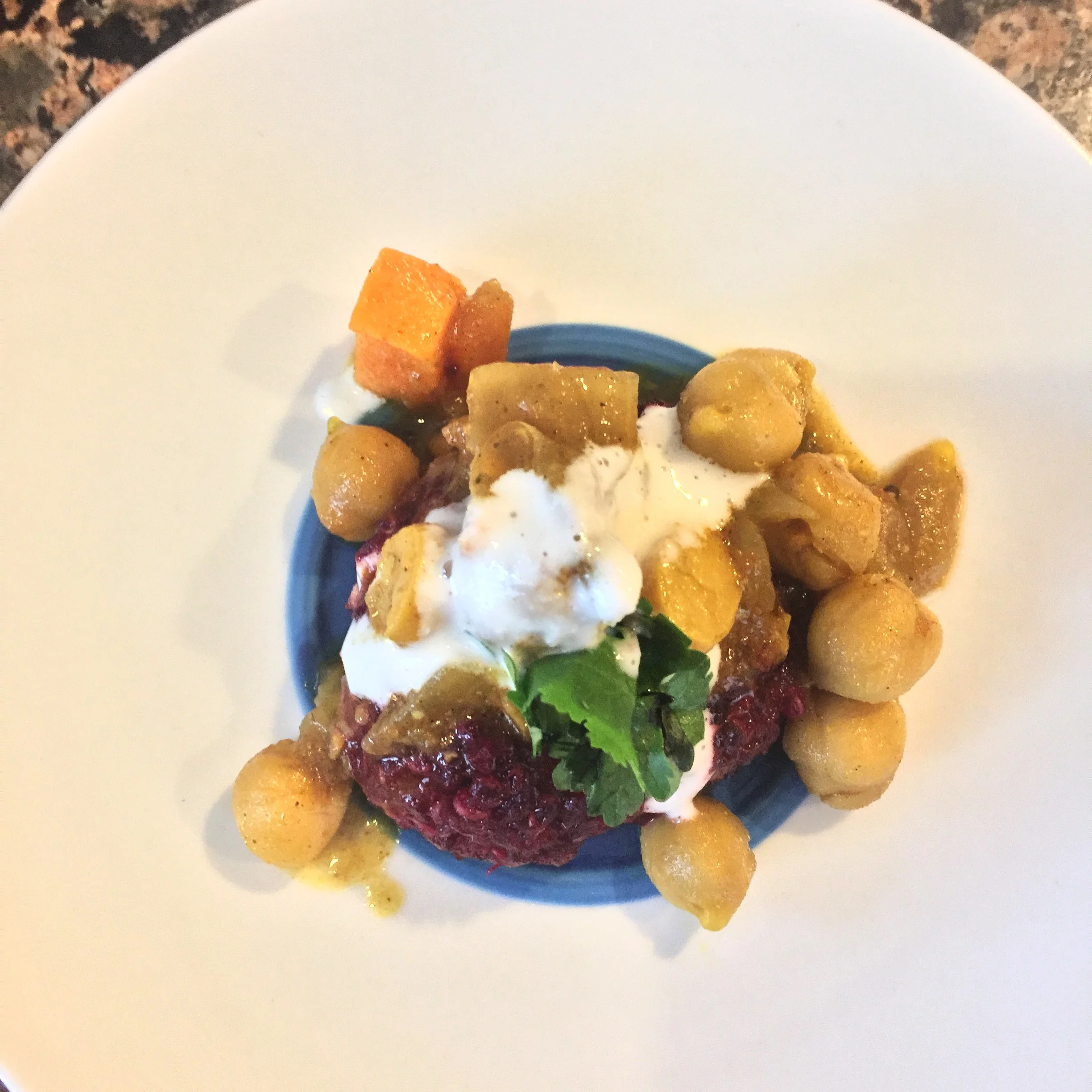 Beet and quinoa tikki topped with chana masala, cashew cream and cilantro.