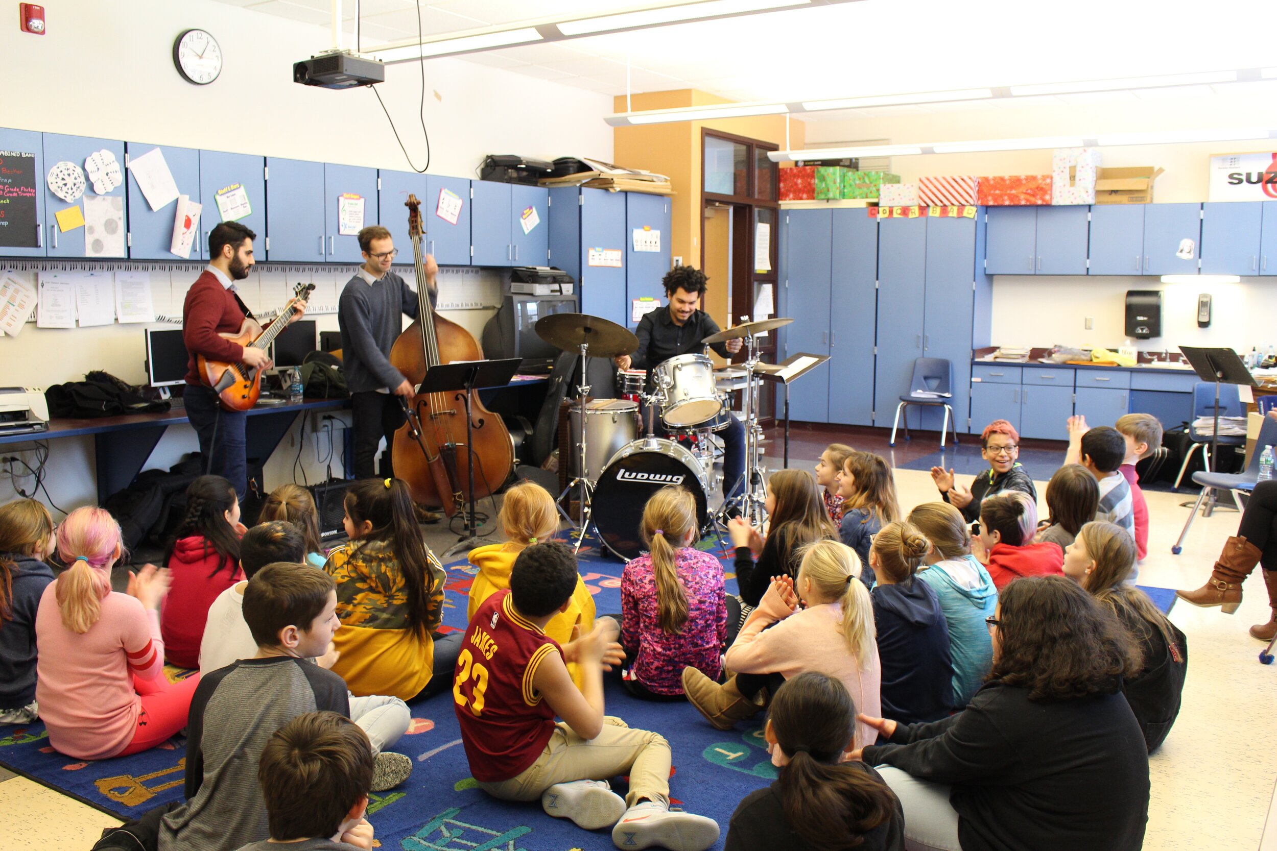 Students smiling and clapping with Adam Moezinia.jpg