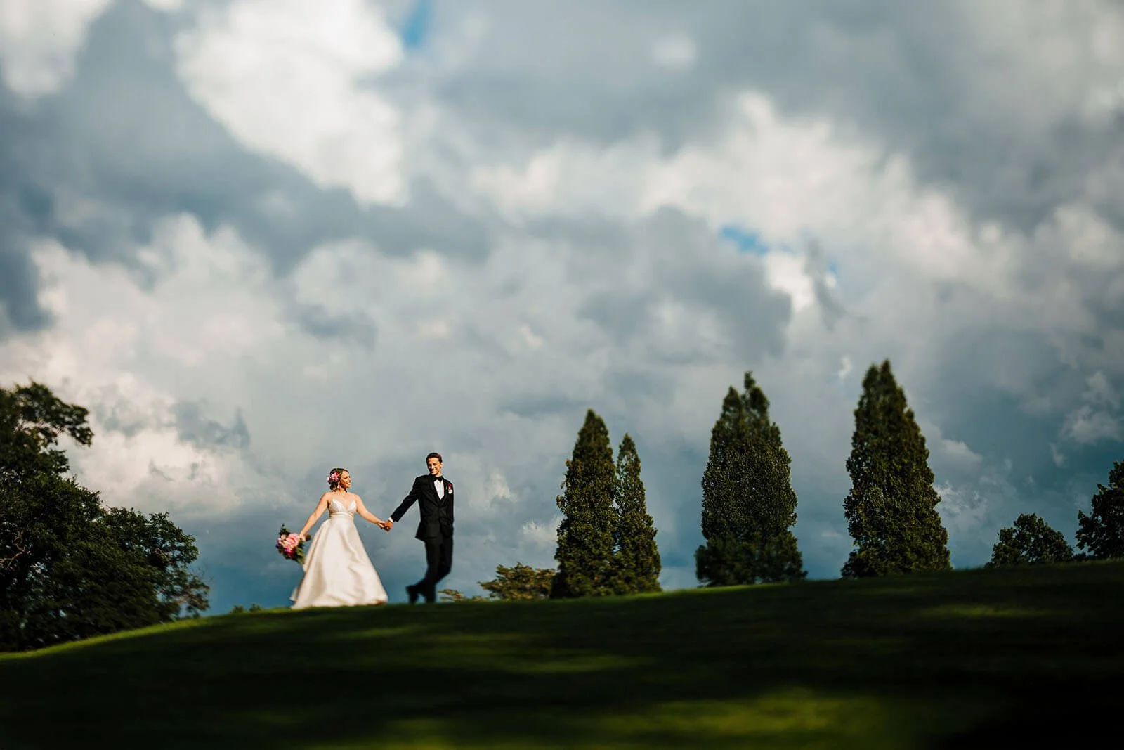 Carriage Greens Country Club wedding photographer Darien Illinois candid bride leading packed dance floor with arms raised and guests all hands up, top luxury Illinois wedding photography