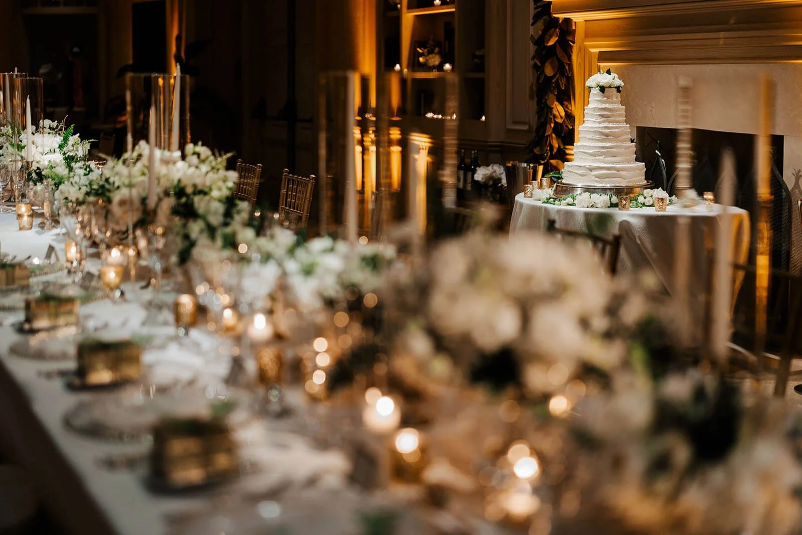 Lost Tree Club wedding photographer North Palm Beach Florida luxury reception gold candles white florals tiered wedding cake by fireplace, top destination wedding photography GAUPERphoto