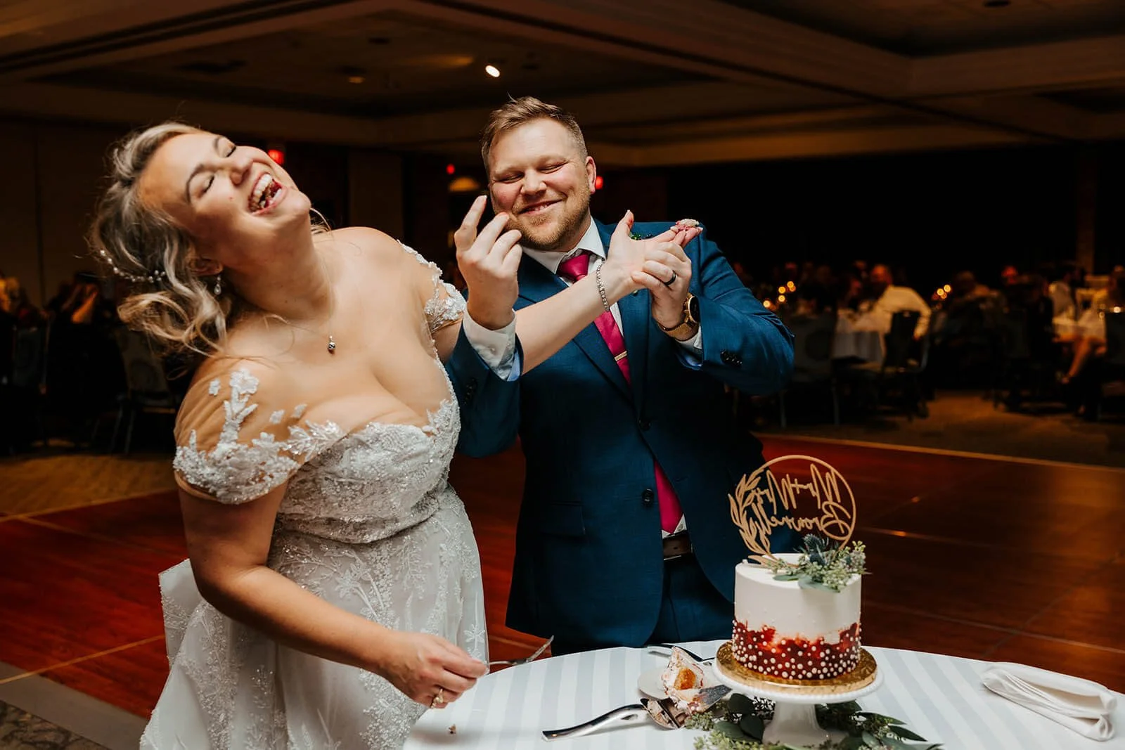 Luxury wedding photographer Grand Rapids Michigan candid bride and groom laughing cake smash, LV Eberhard Center top documentary wedding photography