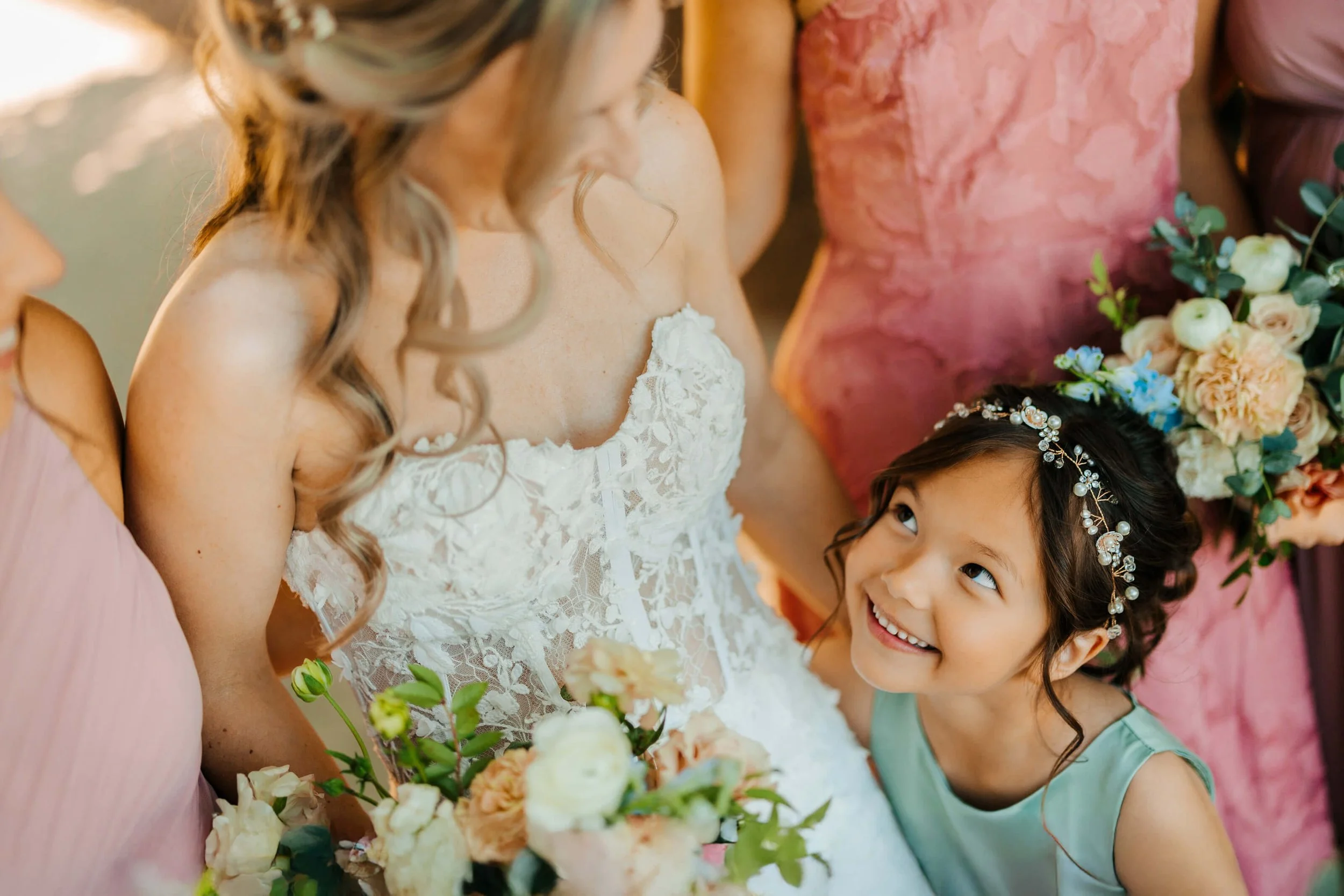 Timberlee Hills wedding photographer Traverse City Michigan candid flower girl looking up adoringly at bride holding floral crown bouquet, top Northern Michigan wedding photography