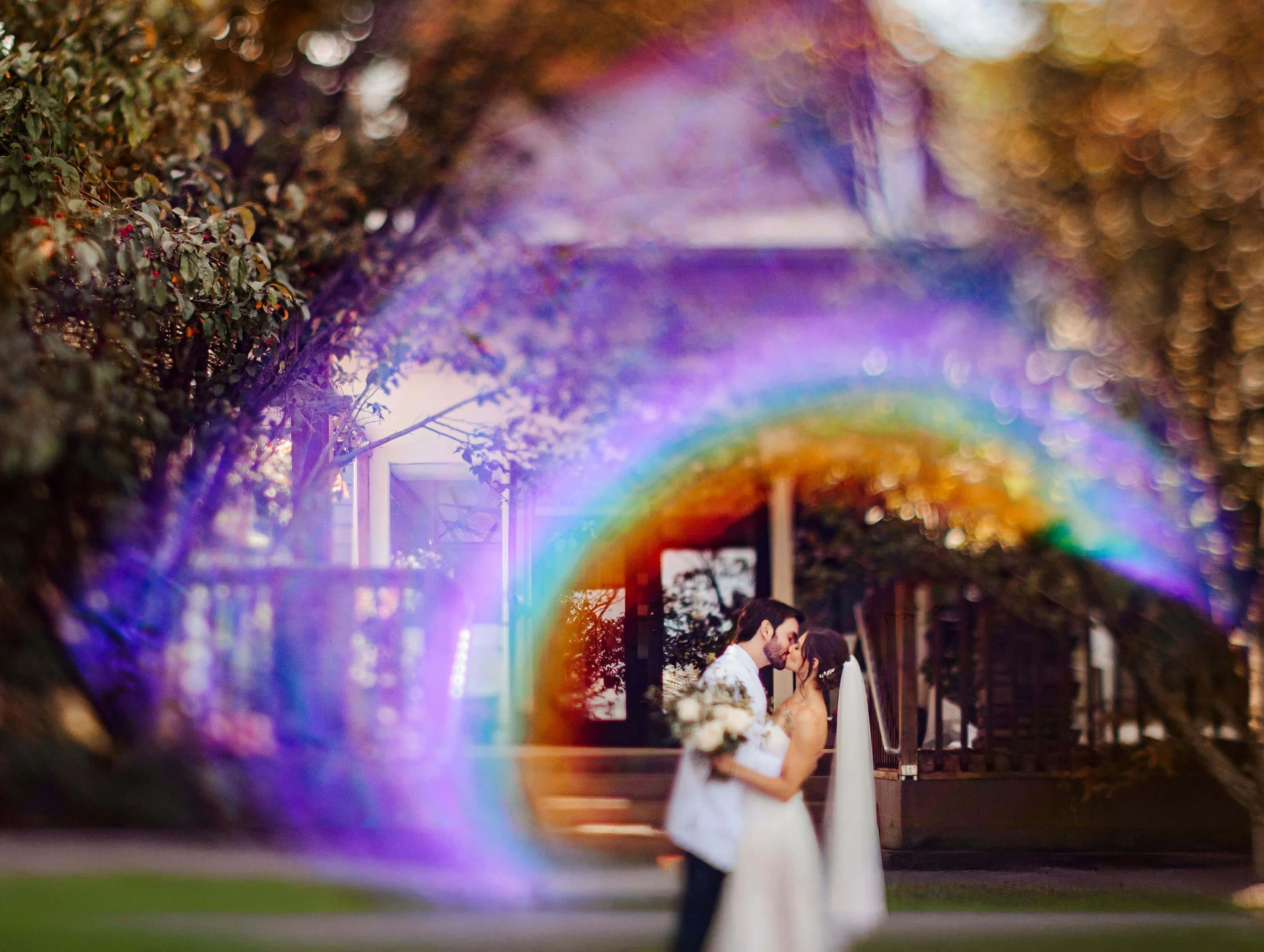 Timberlee Hills wedding photographer Traverse City Michigan artistic bride and groom kissing through rainbow lens flare, top Northern Michigan editorial wedding photography