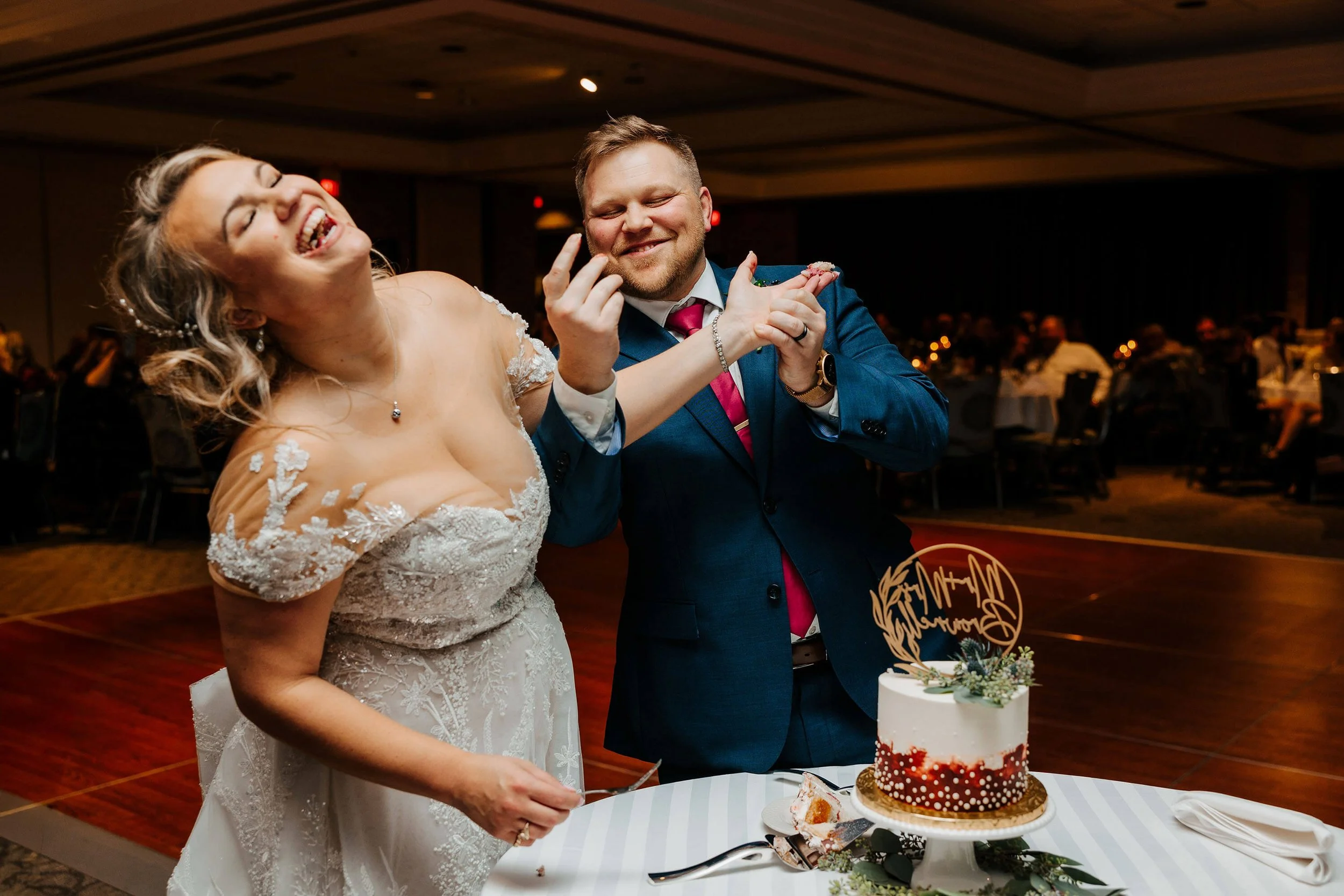 Luxury wedding photographer Grand Rapids Michigan candid bride and groom laughing cake smash, LV Eberhard Center top documentary wedding photography