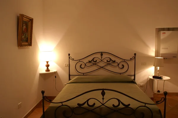 A locally-made iron bed in the bedroom with a countryside view