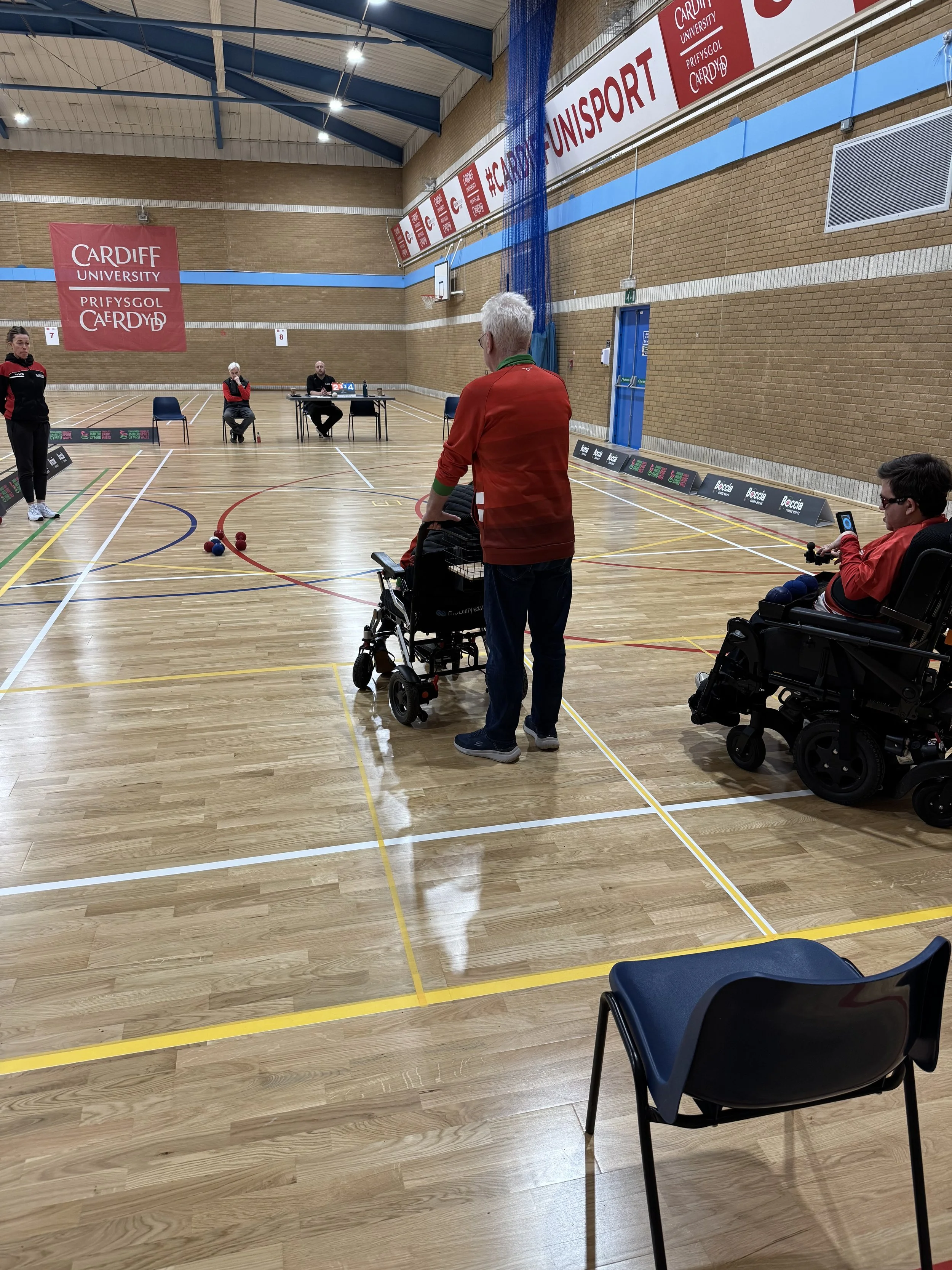 A boccia game is underway in a sports hall