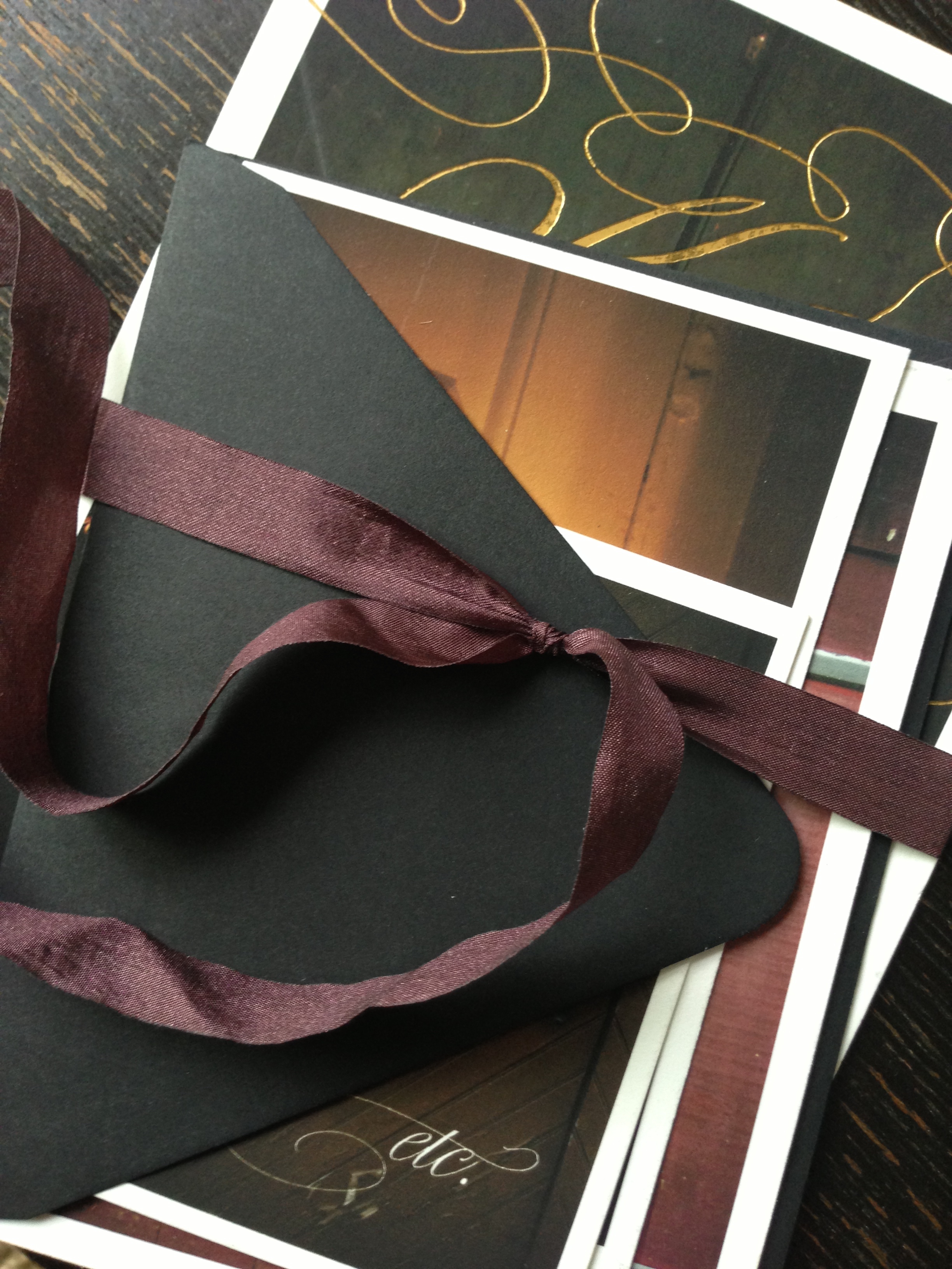   The invitation features cards of different sizes each printed with a photo of a door from the property and bound with a vintage eggplant colored ribbon.&nbsp;     