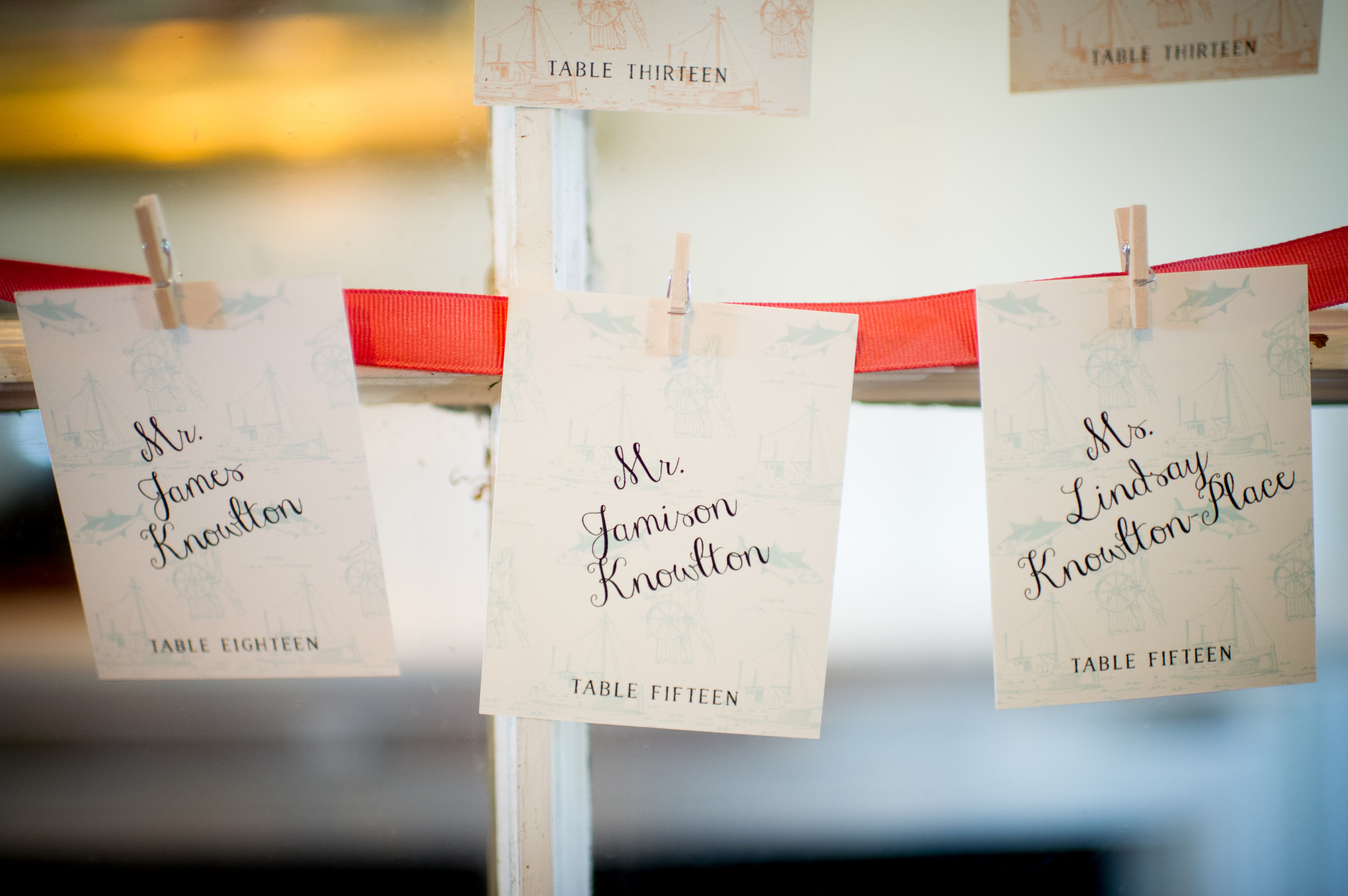  Escort cards were printed with the same toile used in the envelope liner in faint contrasting colors and strung from ribbon.&nbsp; 