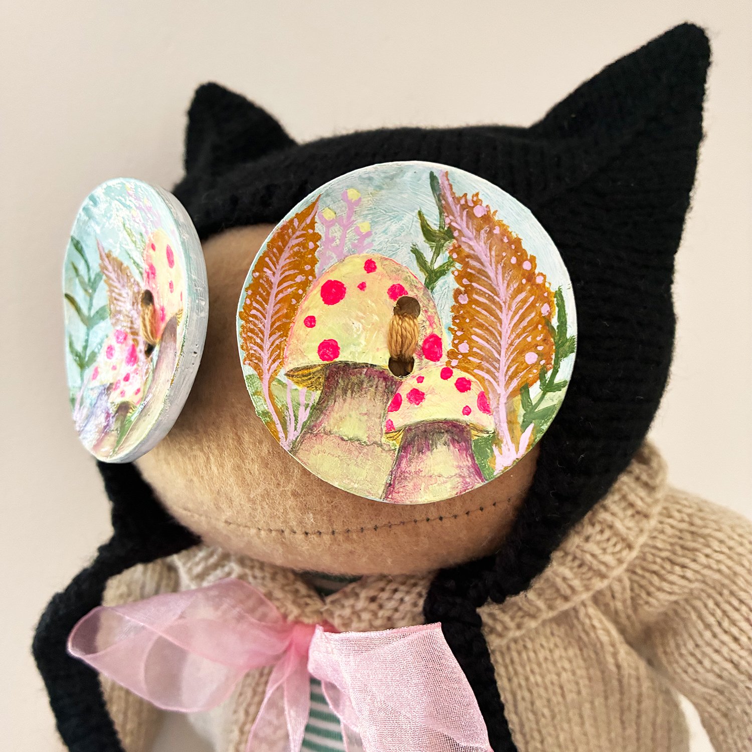 Close-up of Mushroom Rita's hand-painted eyes showing pink mushrooms and green woodland plants