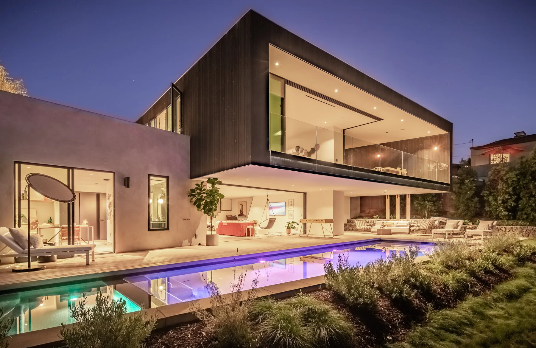  A beautifully designed and executed second-story cantilever provides expansive indoor/outdoor main-level living while providing a calm understory of shade and a modernist mood around the ground level with outdoor seating, a pool, and spa. 