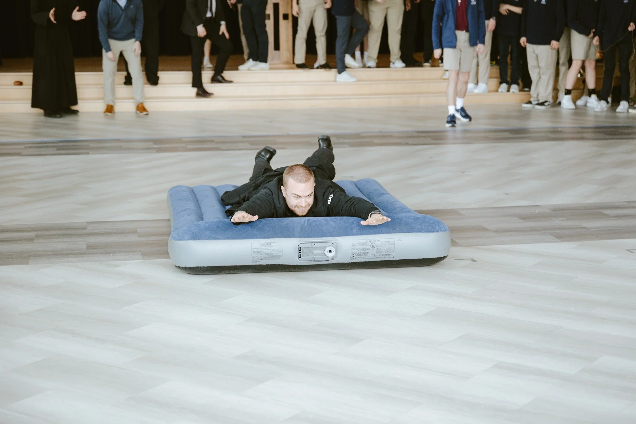 During their recent Pep Rally, Br. Levi Mary and Br. Simon and their colleagues ended up winning the mattress-sliding-relay race, upsetting the fastest student team. The joy at John Paul the Great was palpable!