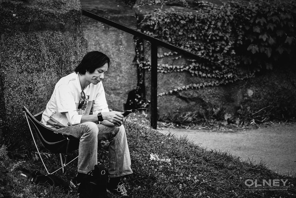 Man playing a videogame in Lafontaine park Montreal OLNEY photographe Sherbrooke