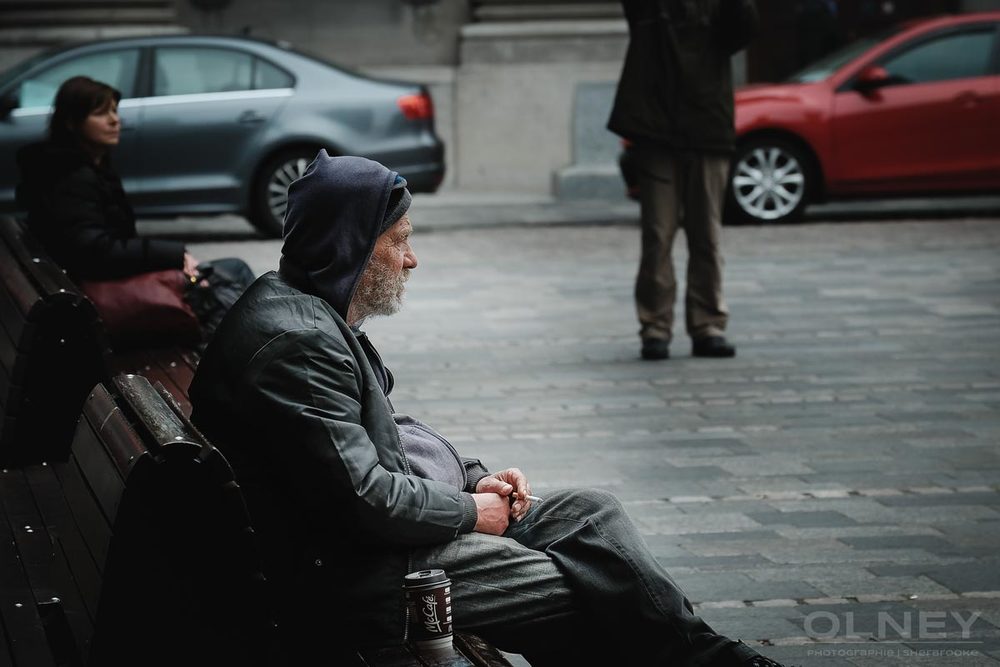 Homeless sitting in Place d'Armes in Montreal
