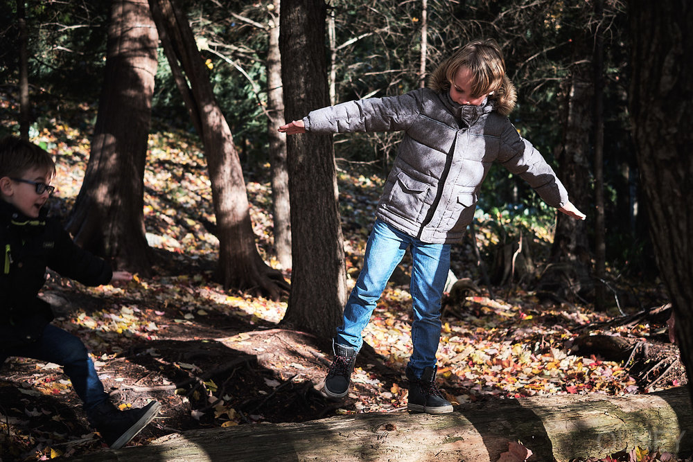 kid standing on a log