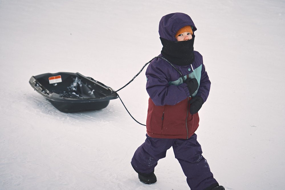 young girl towing a sled