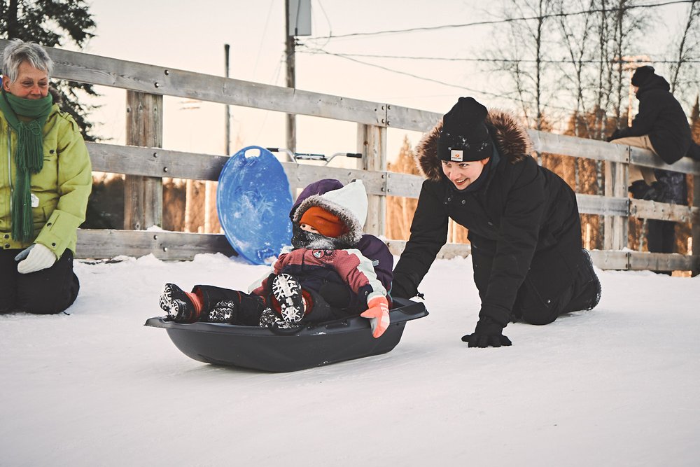 mother pushing sled and kids