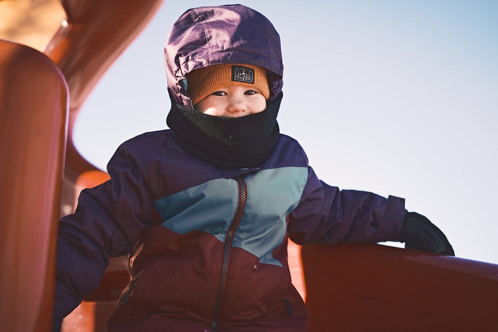 young girl in slide in winter suit