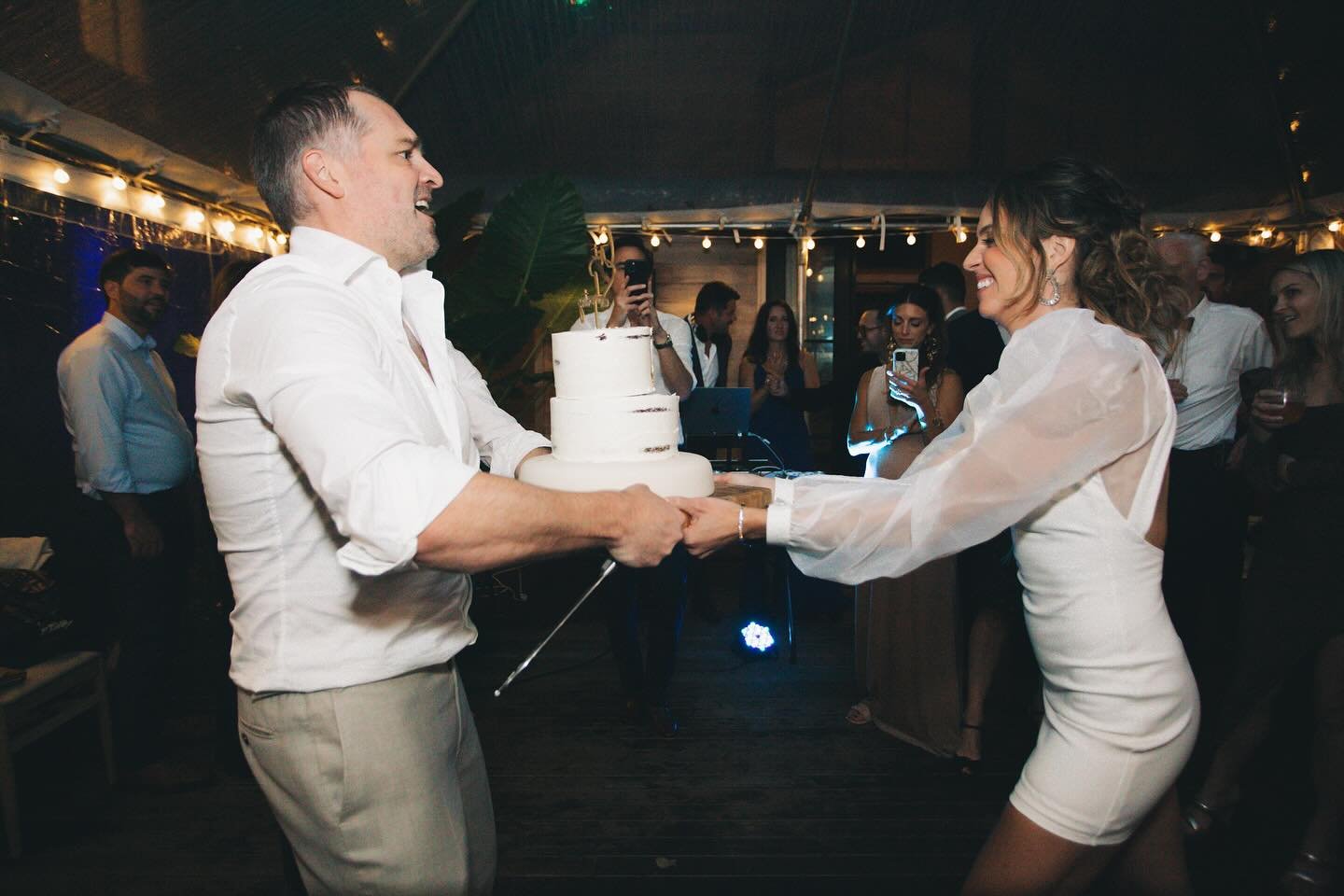 One of my favorite weddings ever! A beach wedding in the Hamptons that was rained out, but they improvised nicely moving everything to their (stunning) home backyard and threw the most epic receptions ever ✨ An incredibly FUN couple cutting cake here