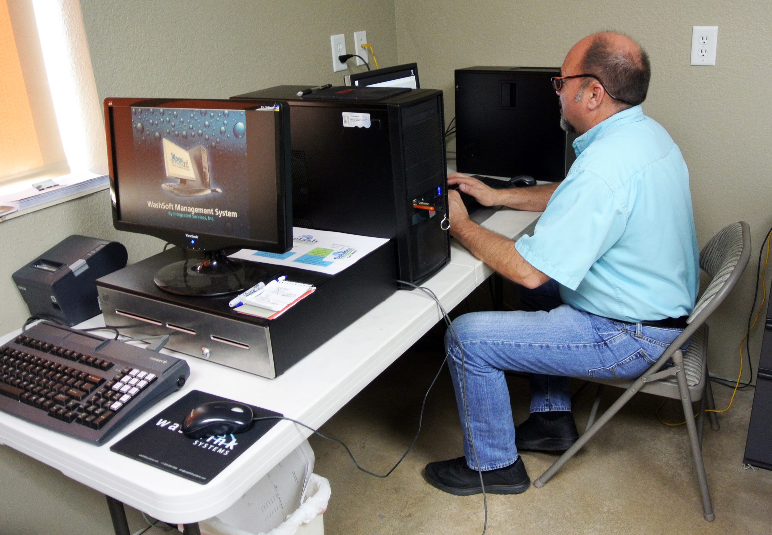 Retired ISI WashSoft (left) replaced by Saleslink POS (right). Owner Burk Morgan deep into setting up his new system. The simpler Washlink POS enabled Burk to get started immediately after setup. (Notice the Washlink Systems mouse pad. The only thing still operational on the ISI system.) Welcome to the Washlink Systems family Burk and your Splash Express team.
