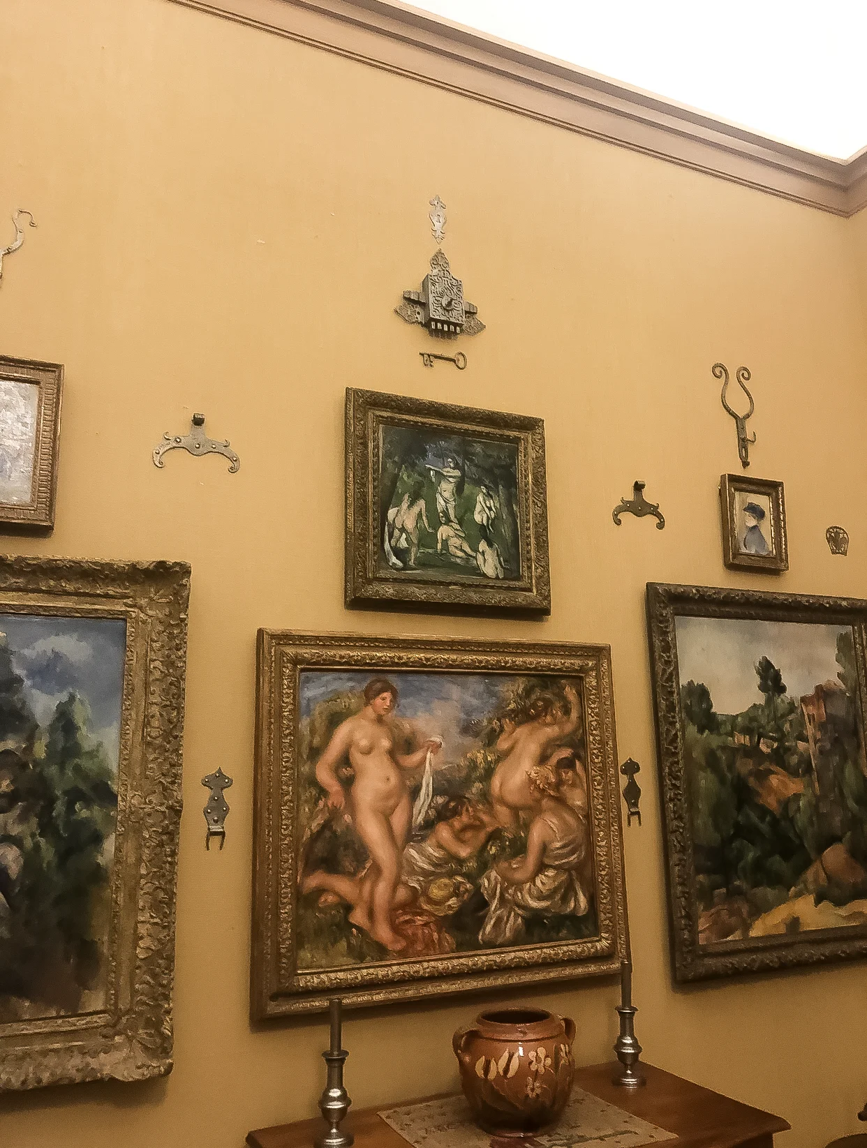 This Renoir surrounded by Cezzanes shows Renoir’s smooth painting style against Cezzane’s signature strokes leaning towards Cubism. Also notice the Free mason iron work displayed to contribute to whole aesthetic.(Personal Photo)