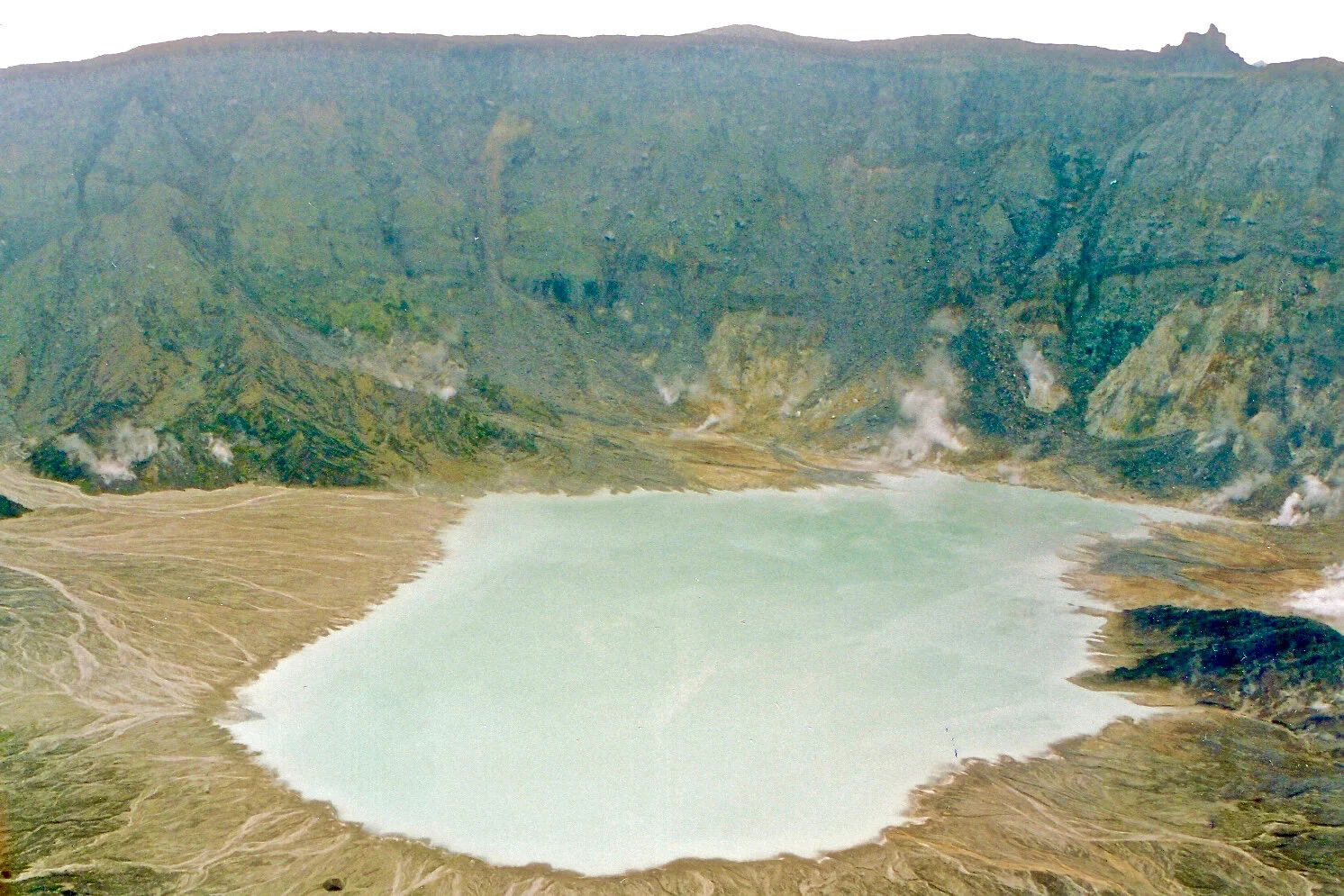   Le lac central doit sa couleur verdâtre à son acidité chlorée, la base du versant étant jalonnée par des fumerolles à l’odeur très caractéristique d’hydrogène sulfuré (“œuf pourri”). Les ressauts sur le versant révèlent l’alternance de couches de laves formant corniche et de couches de cendres, structure typique d’un stratovolcan dont la base s’inscrit ici dans un quadrilatère d’environ 6 km sur 9 km.  