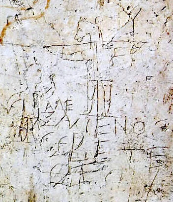 Ce graffiti, découvert en 1897 dans les vestiges de la “domus Gelotiana” à Rome est daté autour du 2e siècle. Il caricature la croyance des chrétiens en Jésus : une forme humaine crucifiée, affublée d’une tête d’âne, est saluée ou honorée par un personnage debout en contrebas. Le texte gravé (dans un grec approximatif qui veut indiquer le lieu d’origine – l’est de la “Mare Nostrum” – de cette nouvelle croyance) signifie « Alexamenos adore (son) Dieu » (Musée du palatin – Rome)
