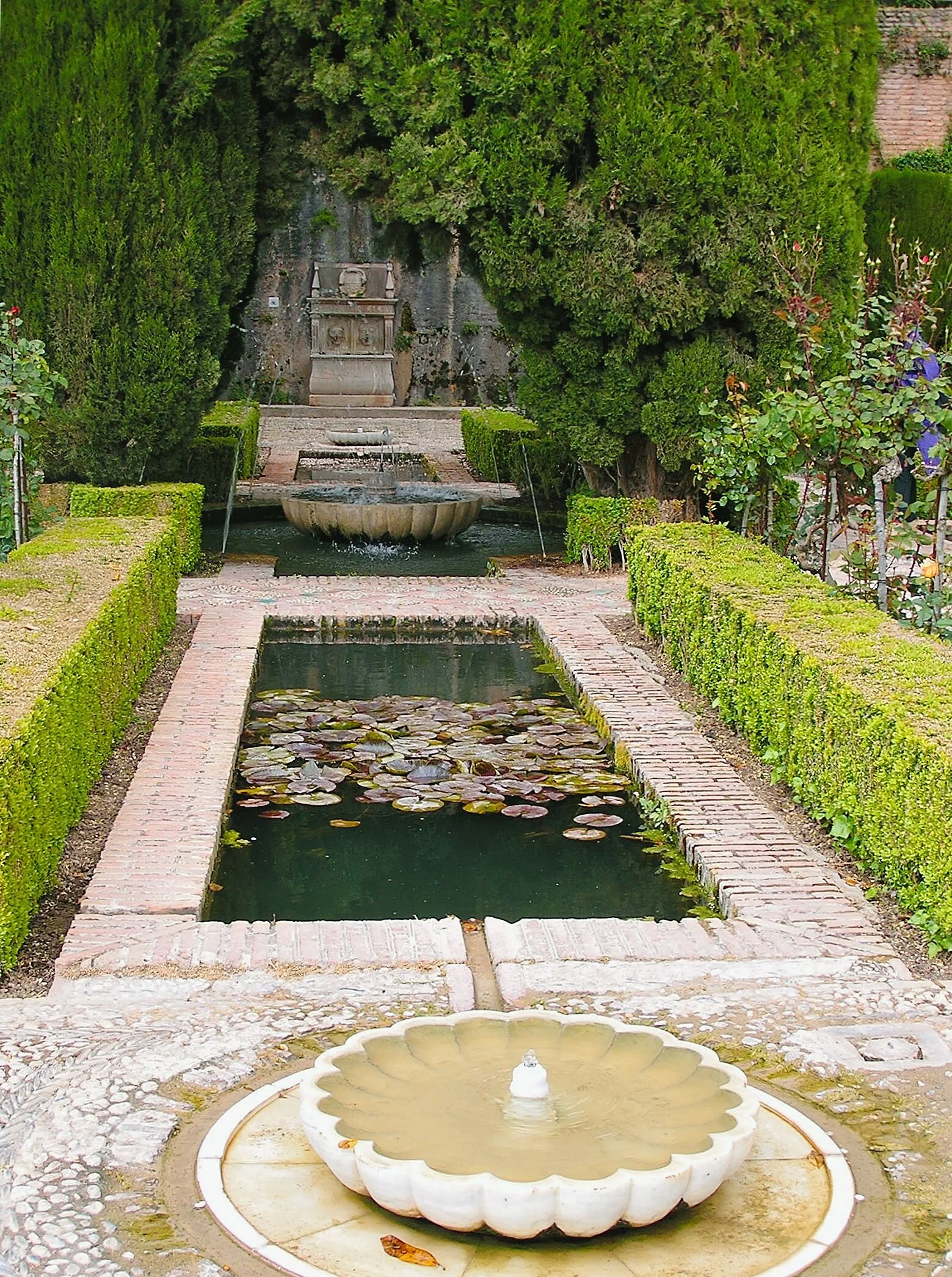 Jardins du Généralife : sur l'autre versant de la colline le “Généralife” était le palais d'été des princes Nasrides, rafraîchit dans les ombrages, par l’omniprésence des bassins et jets d'eau. Son nom est un dérivé phonétique de l'arabe Jannat el Arif signifiant « jardins de l'Architecte », évocation du « paradis » du Coran.