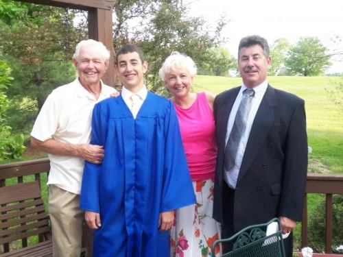 Shane graduating from Moller High School with his grandpa (left) and parents. 