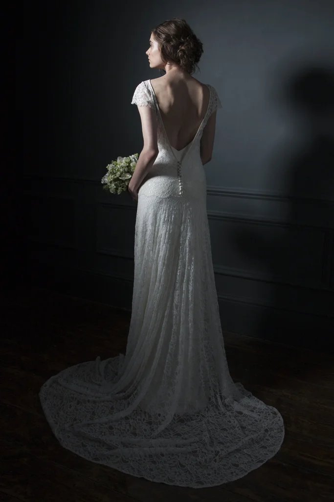 Back view of the Violet Full french lace, low V open back and button details with cap sleeves and V neck crepe back silk Slip Bridal wedding dress by Halfpenny London