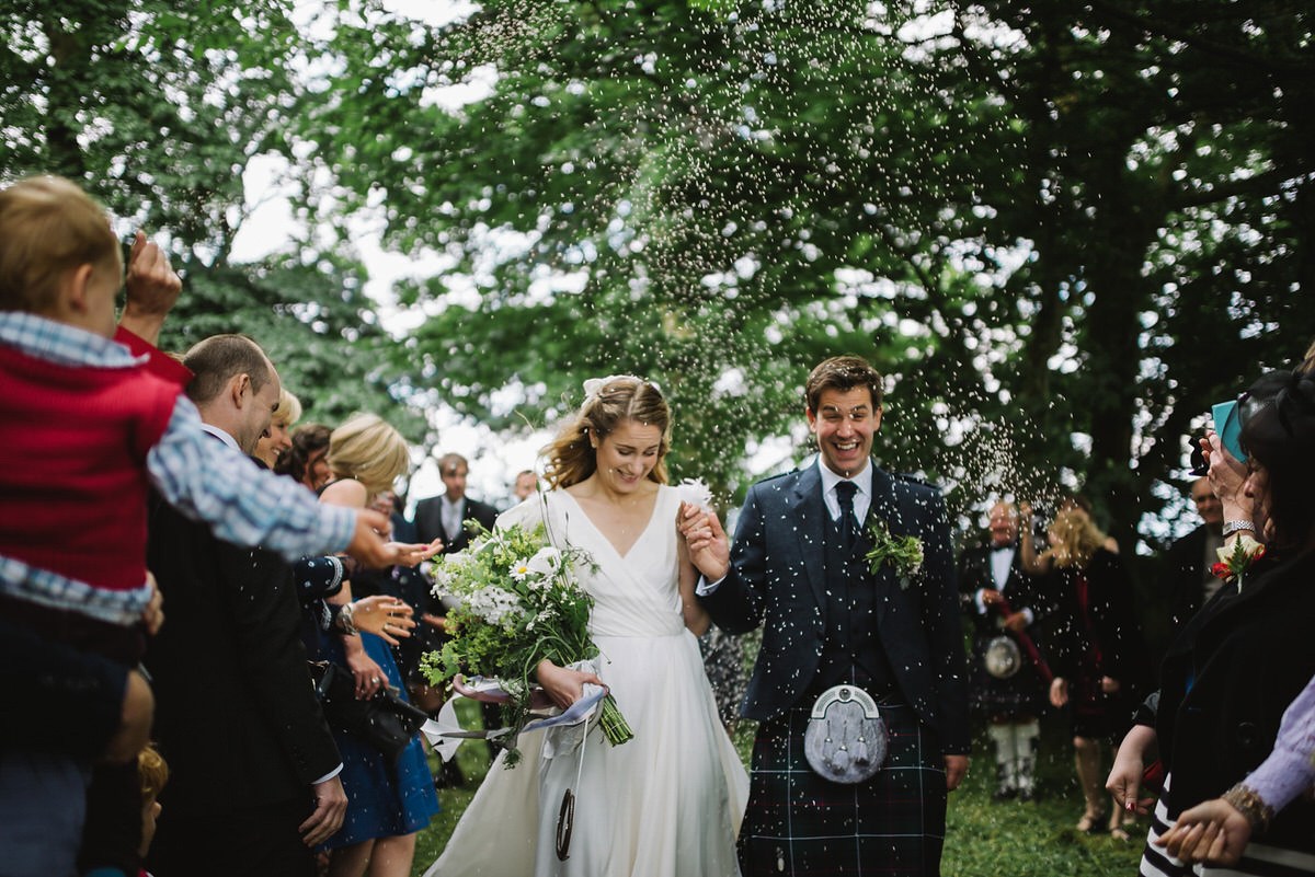 Beautiful Saskia wears a wedding dress by halfpenny London featuring a stunning V back and feather sleeves