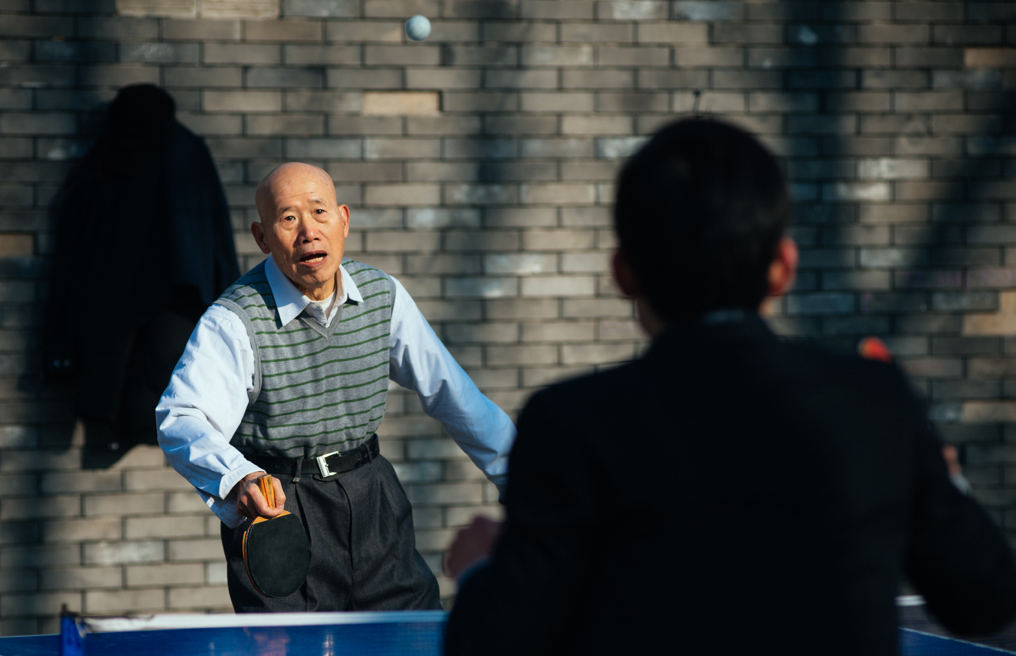 Two men play ping pong in the "free exercise area", right next to what used to be the sacrifice mound of the Temple of the Earth.