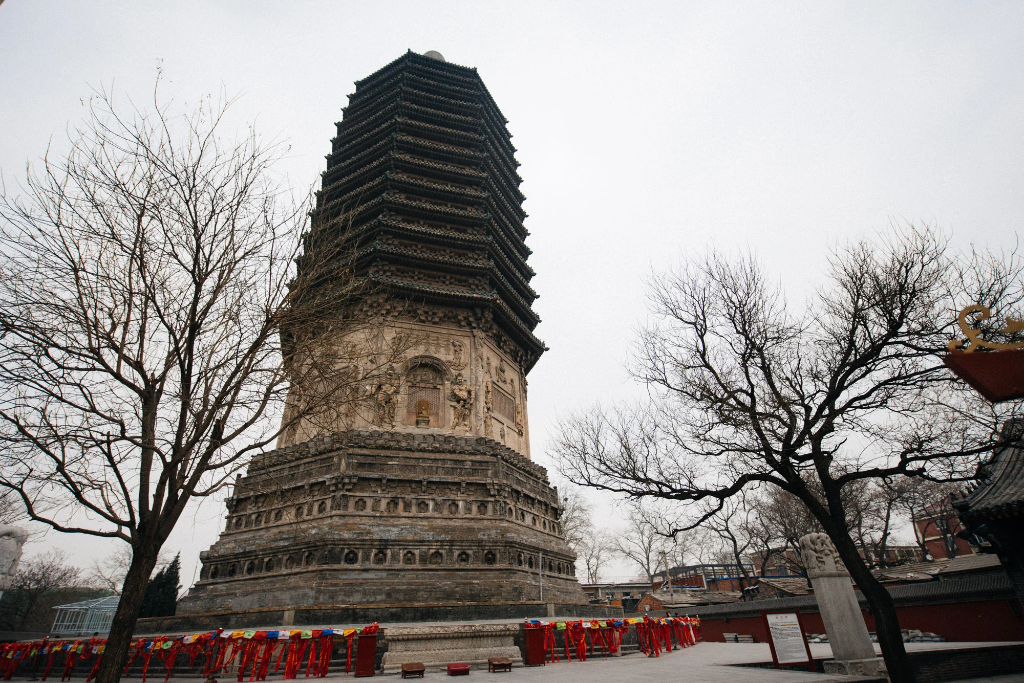 Three layers of huge lotus petals carved on the pedestal support the first storey of the pagoda. On four sides of the first storey, facing the four directions, there are relief sculptures of heavenly guardians and arched gates. Above are thirteen levels of eaves, very close together, with no doors or windows. It is a typical pagoda of the Liao and Kin period. (text from china.org.cn )
