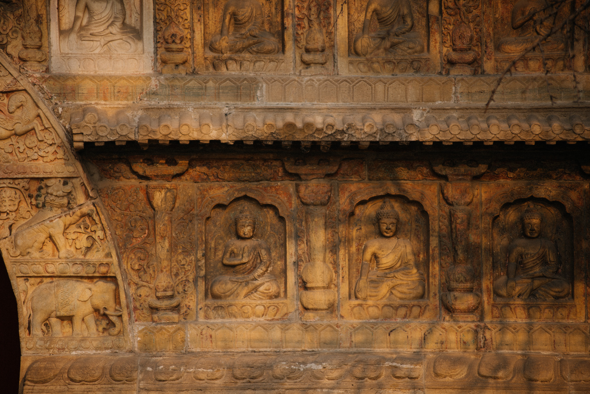 The outer walls are engraved with images of Buddha. The original white marble has turned to black in the past centuries due to oxidation of some of its metal components. It's fairly easy to spot what I suspect are "new" sculpters from recent renovations, such as one on the top left corner. 