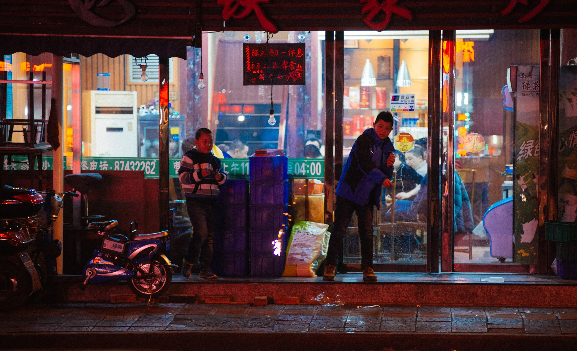 Boys outside a restaurant throw firecrackers in the street, adding to the incessant noise and overwhelming smell of burnt gunpowder.