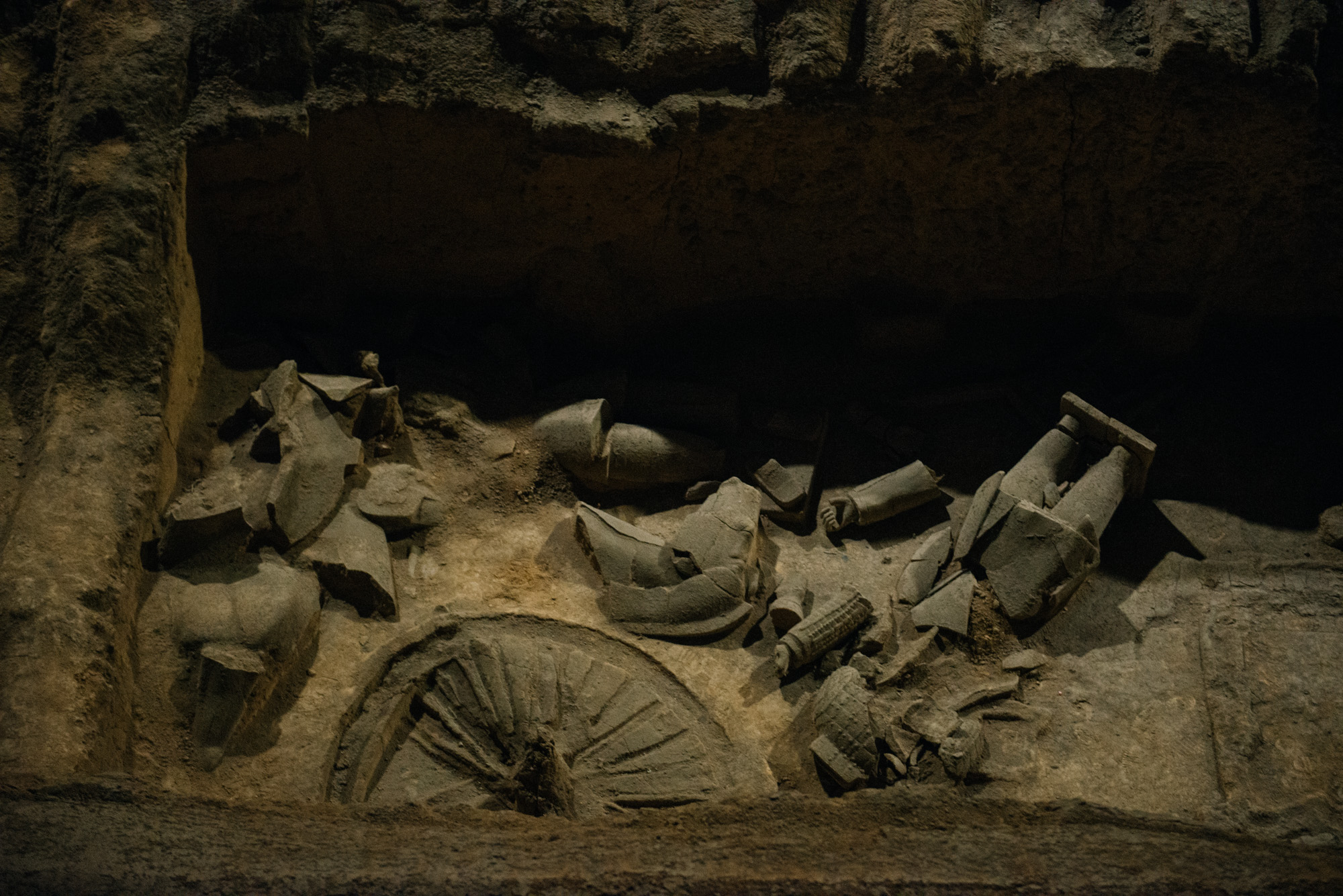 The wheel is actually not there anymore. The wood disintegrated with time and it's print was preserved in the clay.