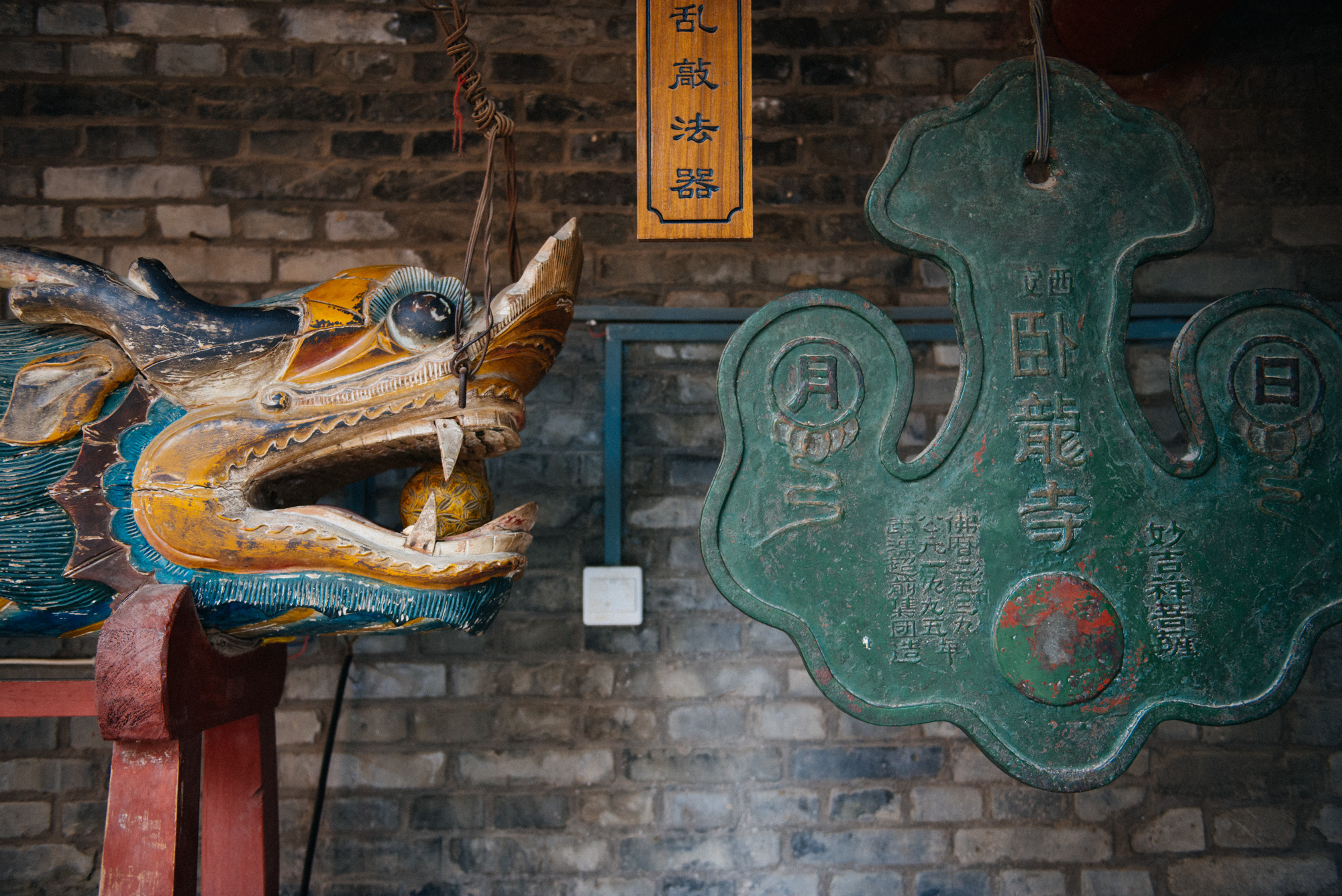 To the right, a bell-like structure and to the left the thing to bang it with. You can see 卧龙寺 (Wolong Temple) written on the "bell" (I don't know how else to call this).