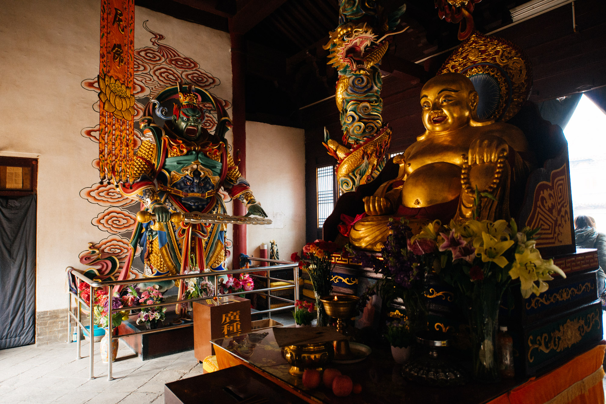 One of the first statues you see when you walk in is this giant golden Buddha and a green warrior (which reminds me of Blanka, no offense). I need to find out who these statues represent. Please comment if you know!