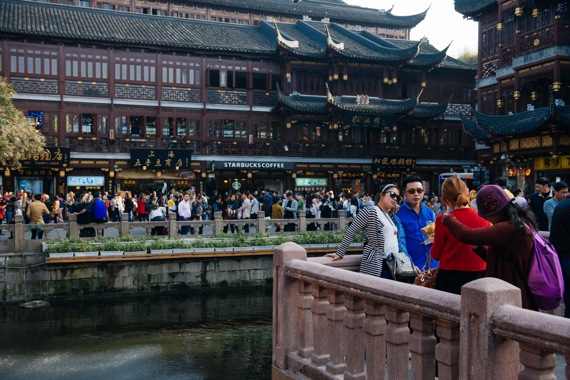 A little further back, another group of tourists poses for pictures with the Starbucks and the suicidal kid from the previous pictures.