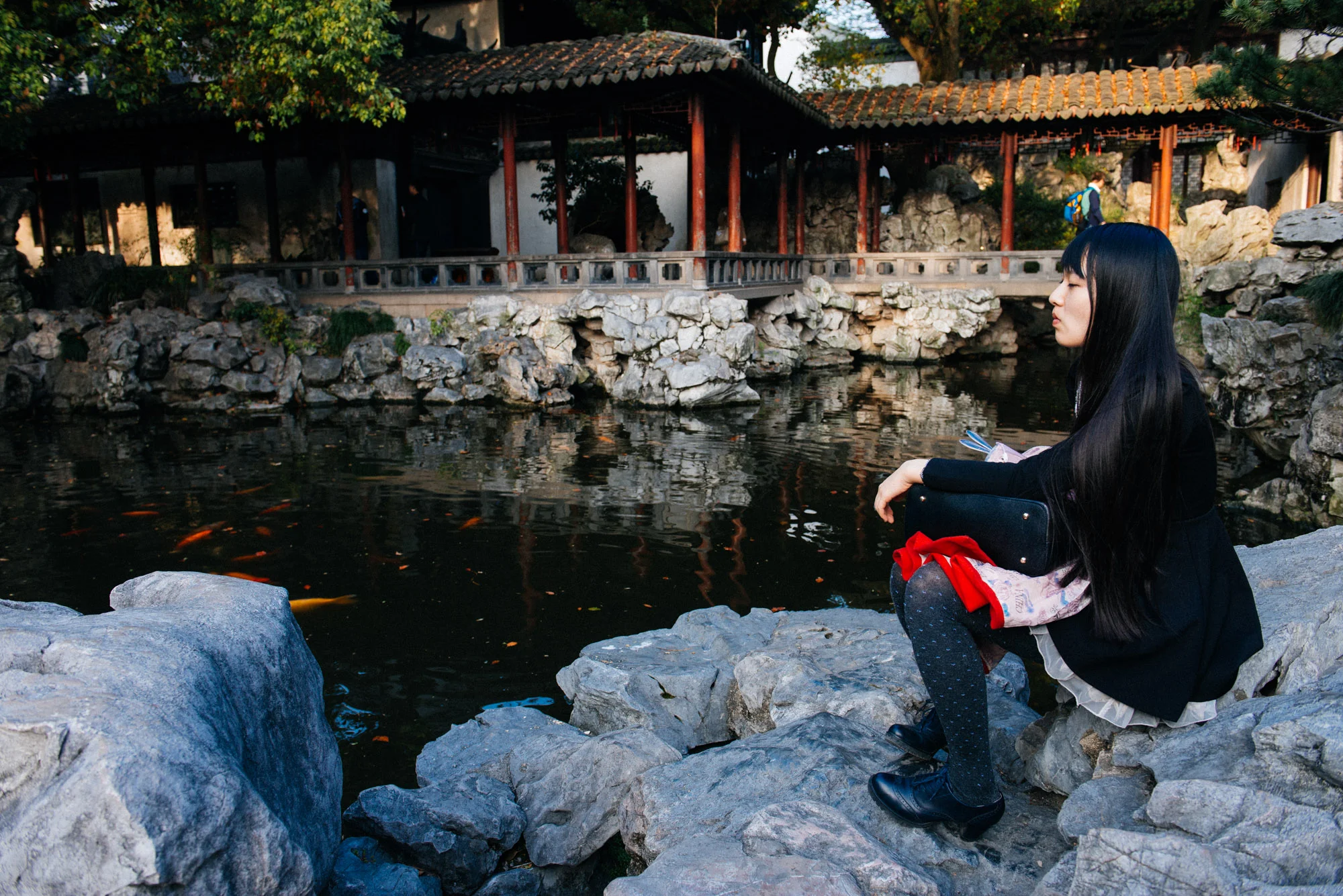 Woman rests and watches the fish swim across the bridge where that other girl was crying.