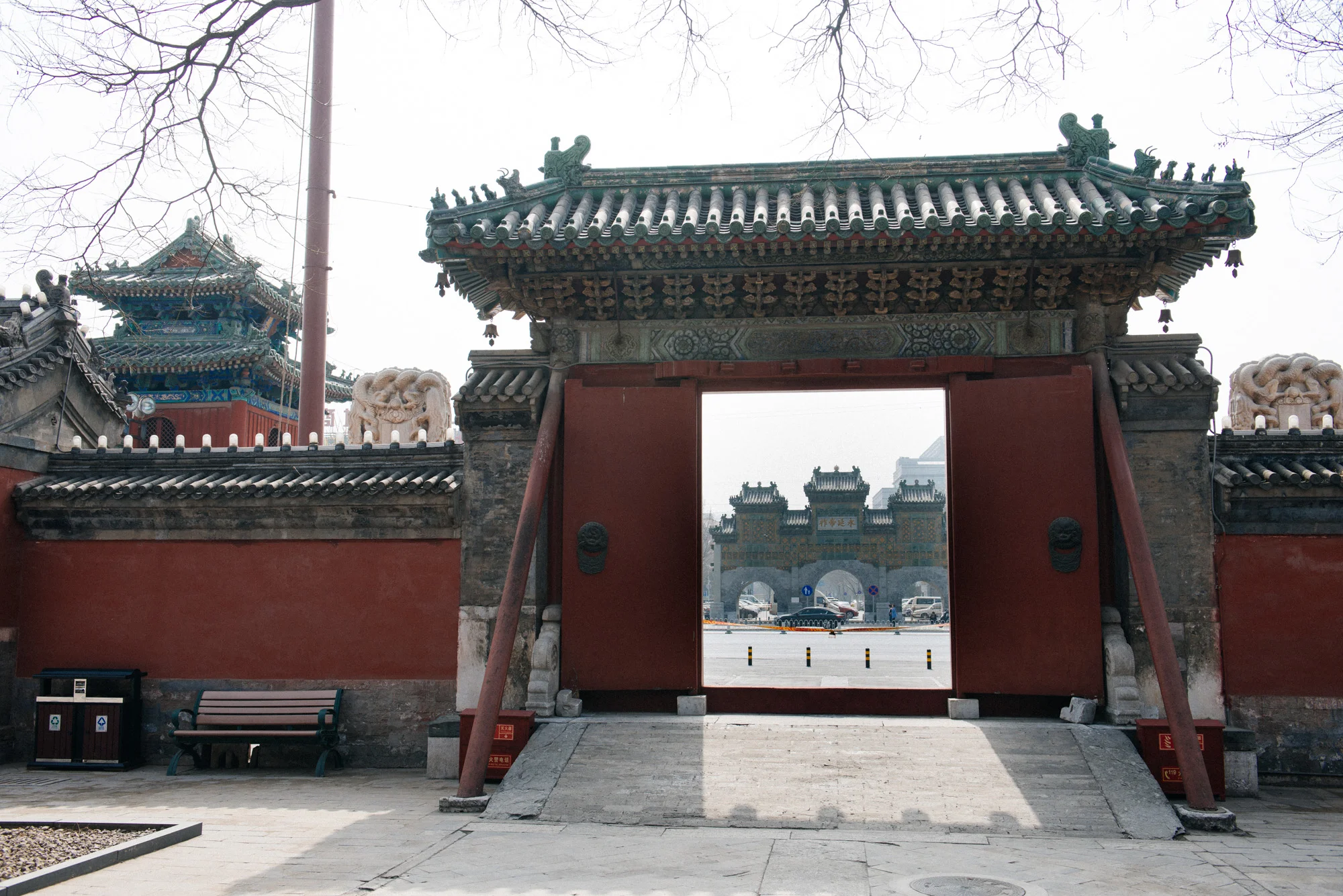 On the other side of a busy street in front of the temple is a large gate.